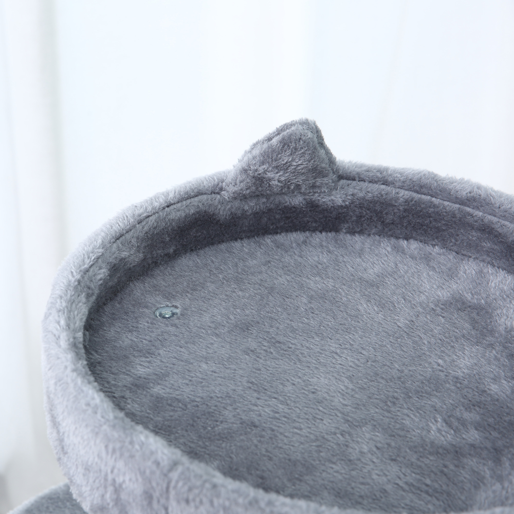 Primer plano de una plataforma gris para árboles para gatos con diseño de oreja. El fondo es blanco.