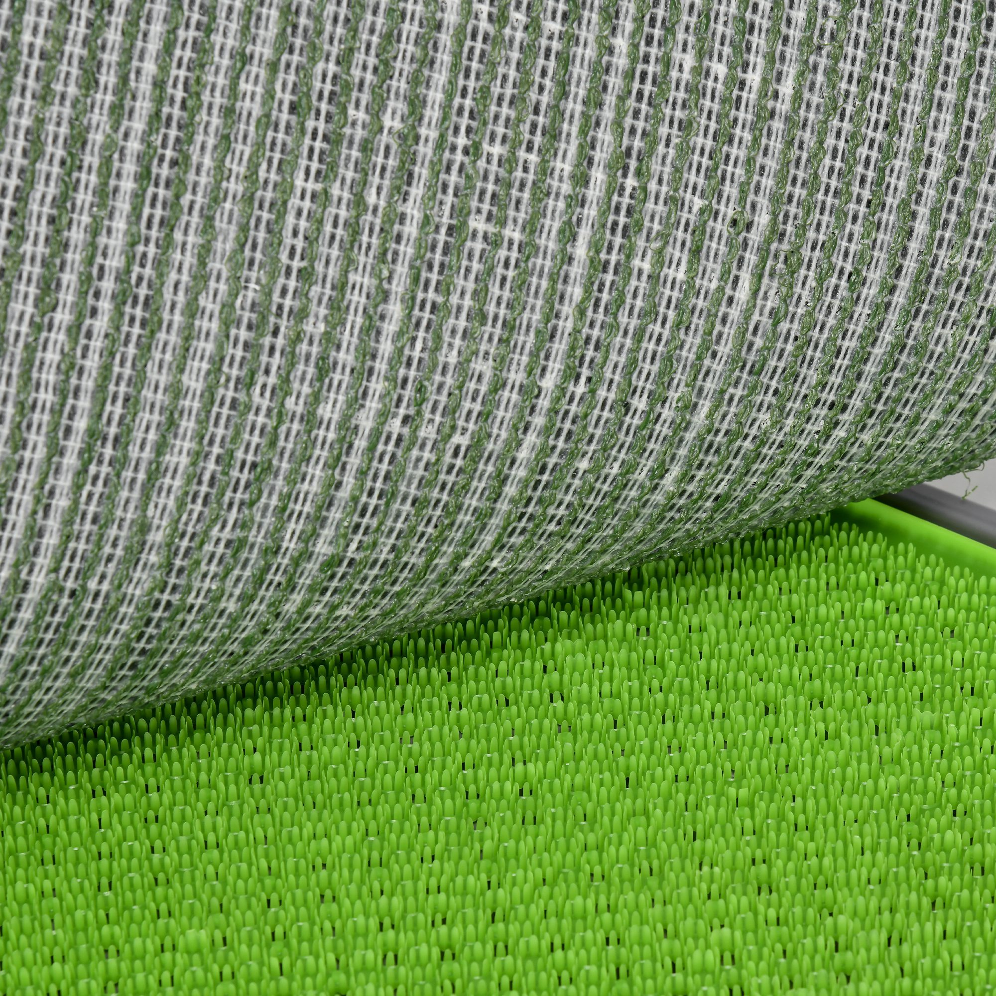 Alfombra verde texturizada con una superposición de malla blanca. La alfombra tiene numerosas protuberancias.