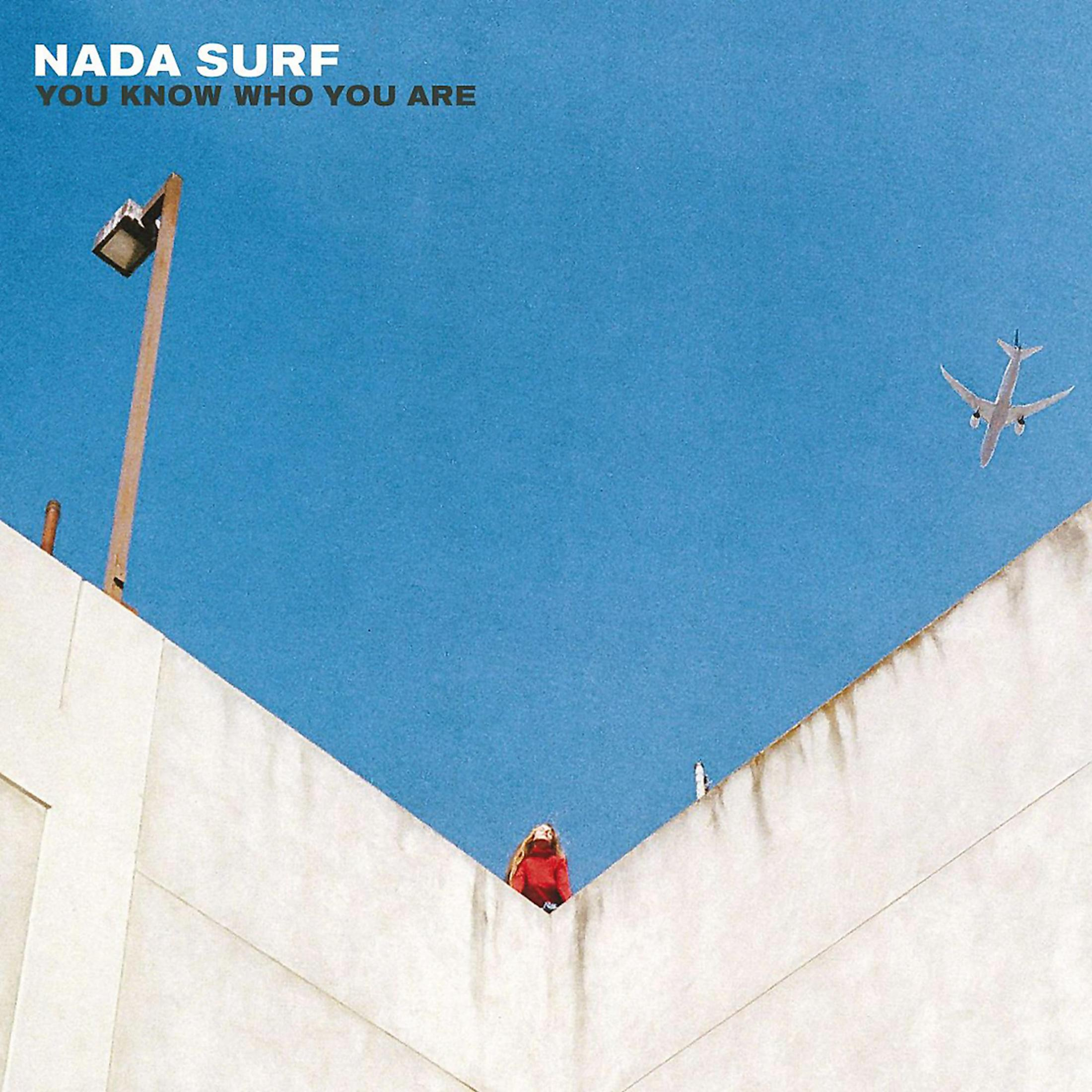 Albumcover: Himmel mit Flugzeug, Person in Rot und Gebäude. Titel: Nada Surf, You Know Who You Are.