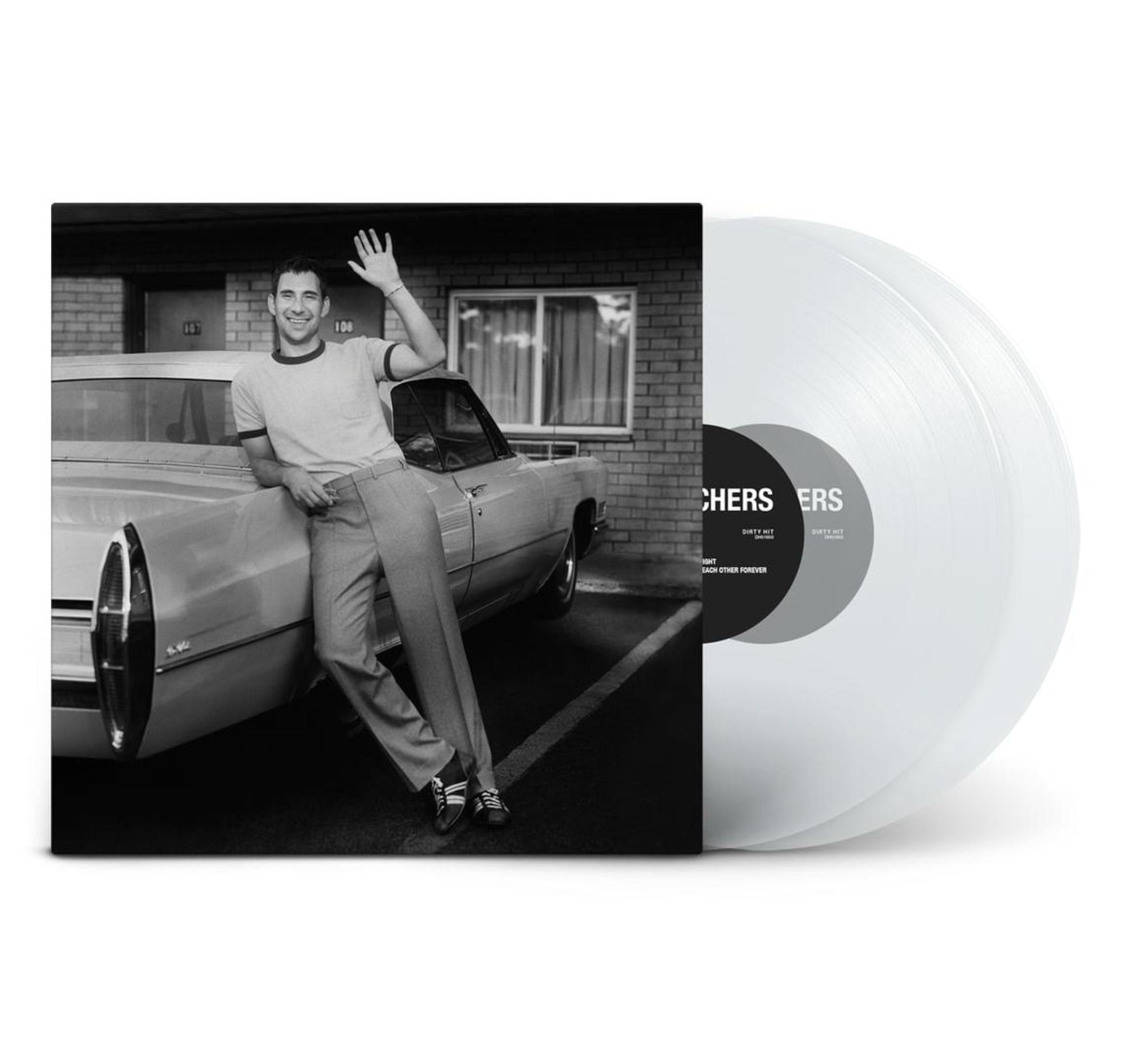 Un uomo si appoggia a un'auto, salutando, vicino a un motel. Un disco in vinile è a destra. Immagine in bianco e nero.