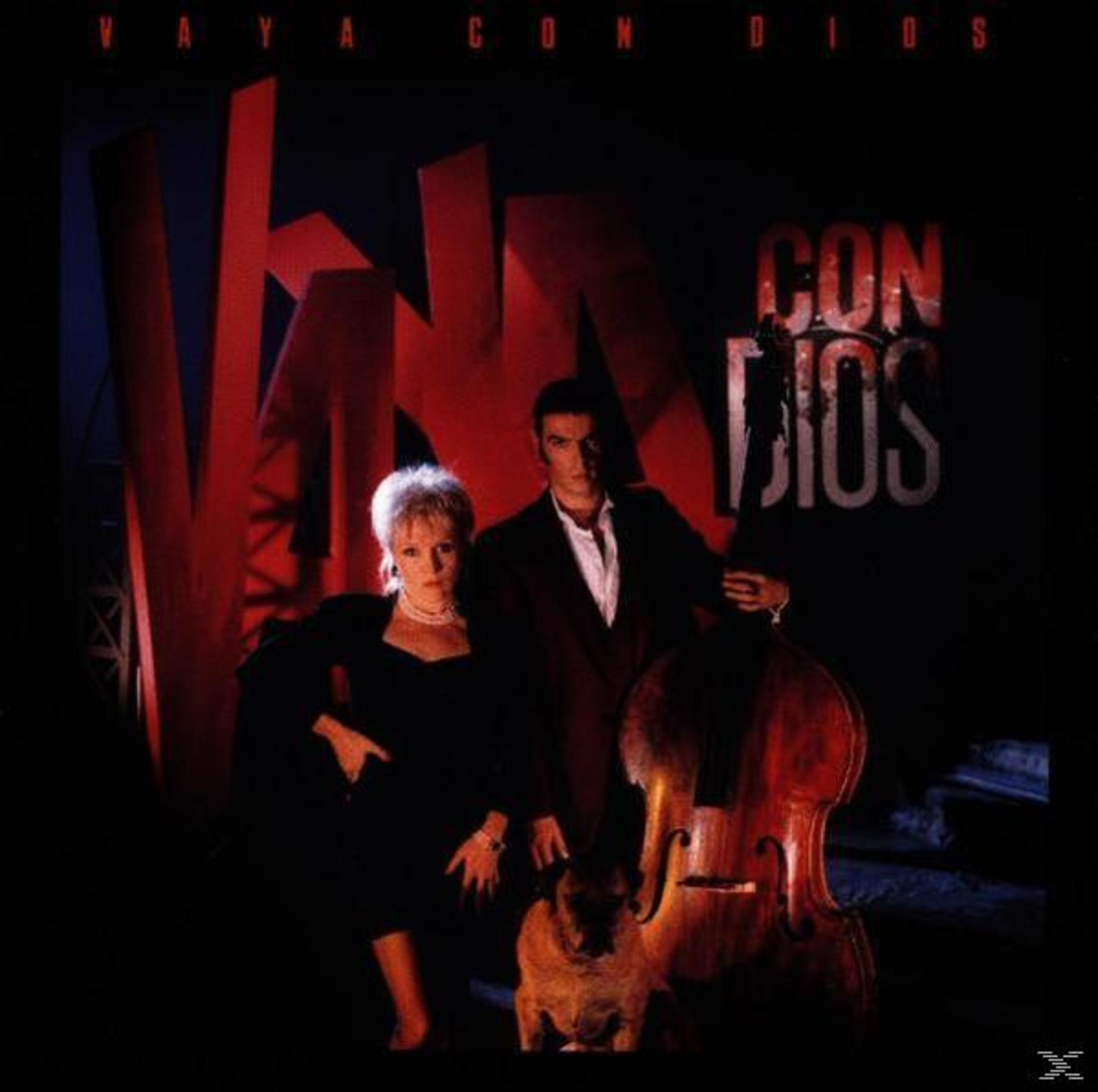 Albumcover: Eine Frau und ein Mann stehen neben einem Hund und einem Cello mit rotem Hintergrundtext.