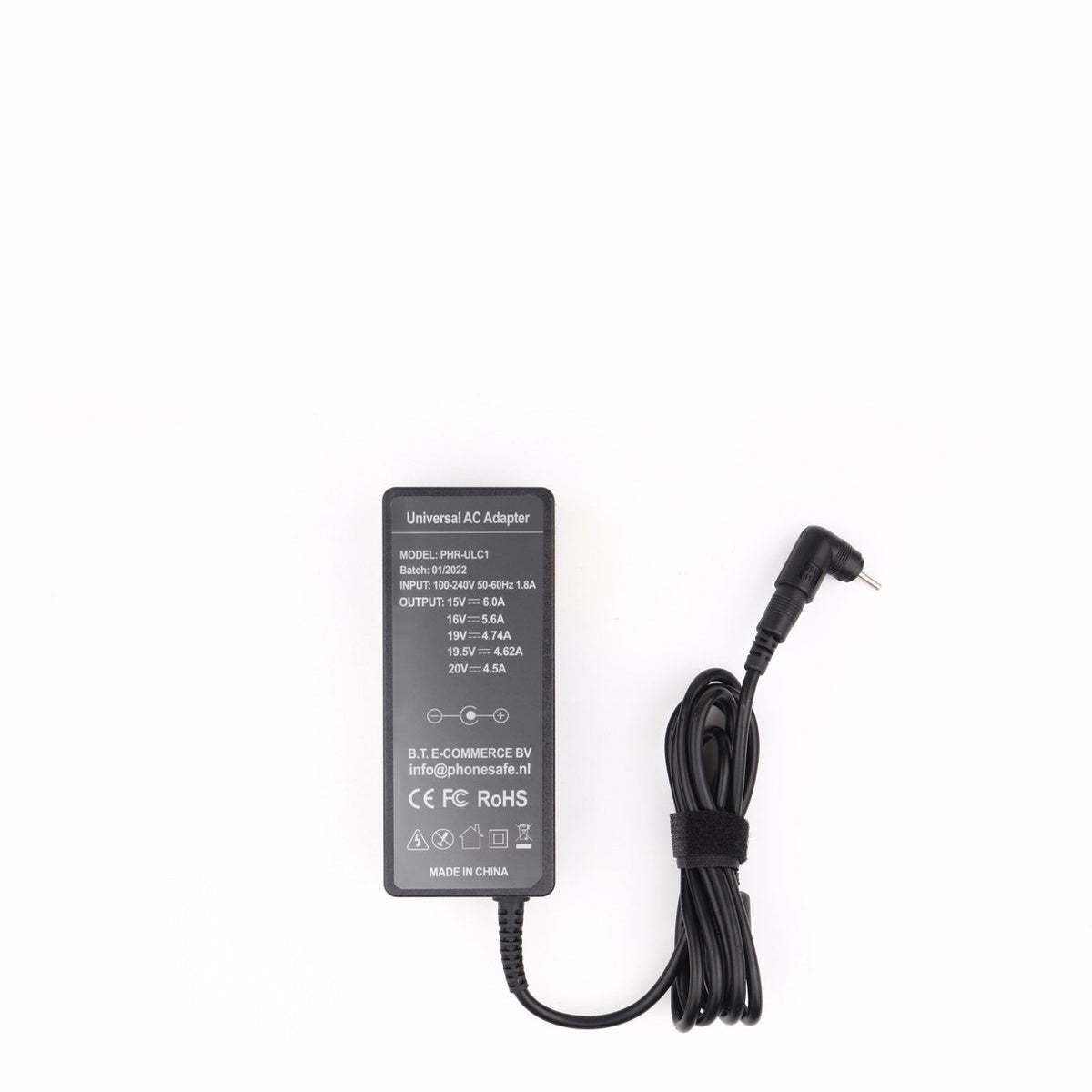 Zwarte universele AC-adapter met aangesloten kabel, gelabeld met specificaties. De adapter staat op een wit oppervlak.