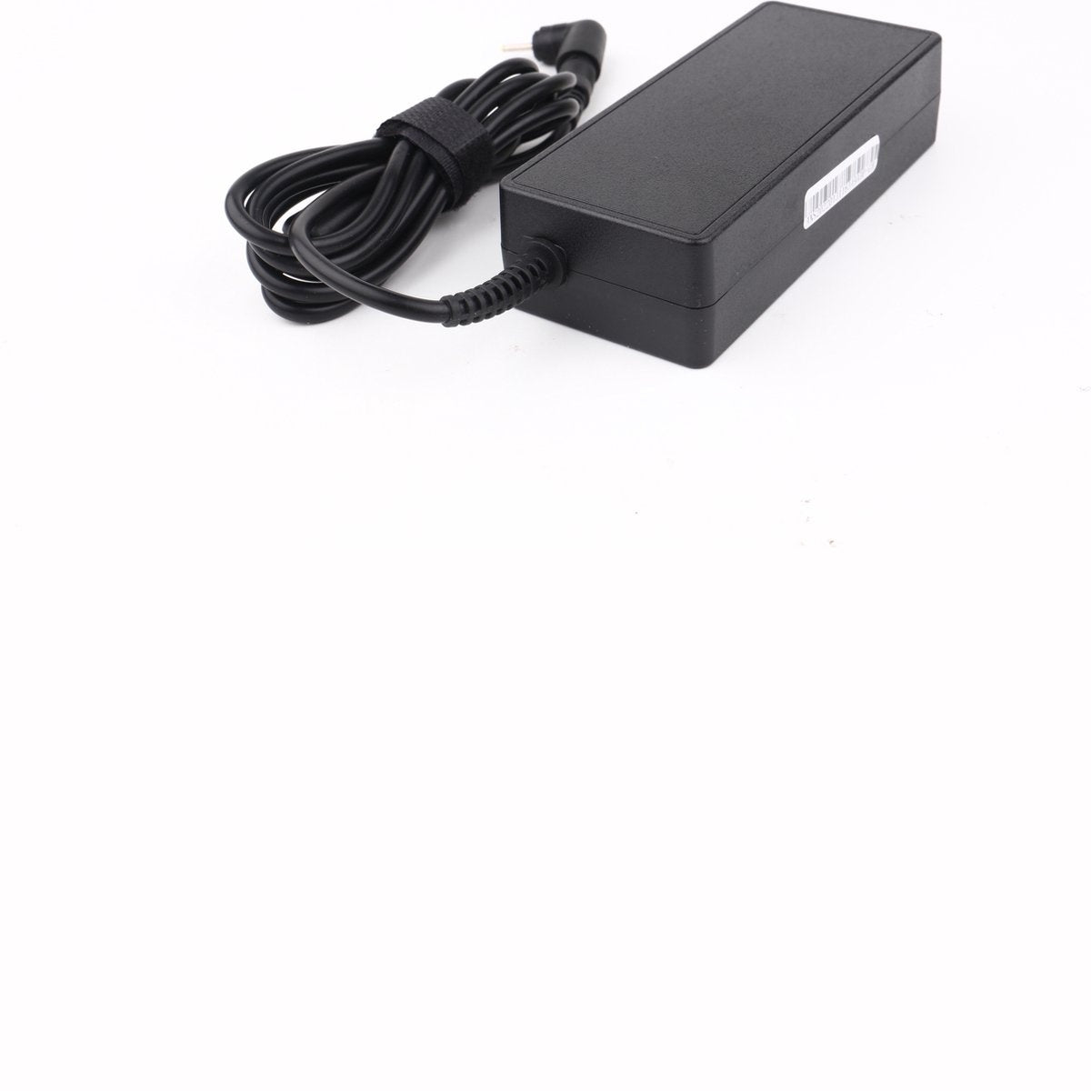 Een zwarte laptoplader met een zwarte kabel en klittenband, op een wit oppervlak.