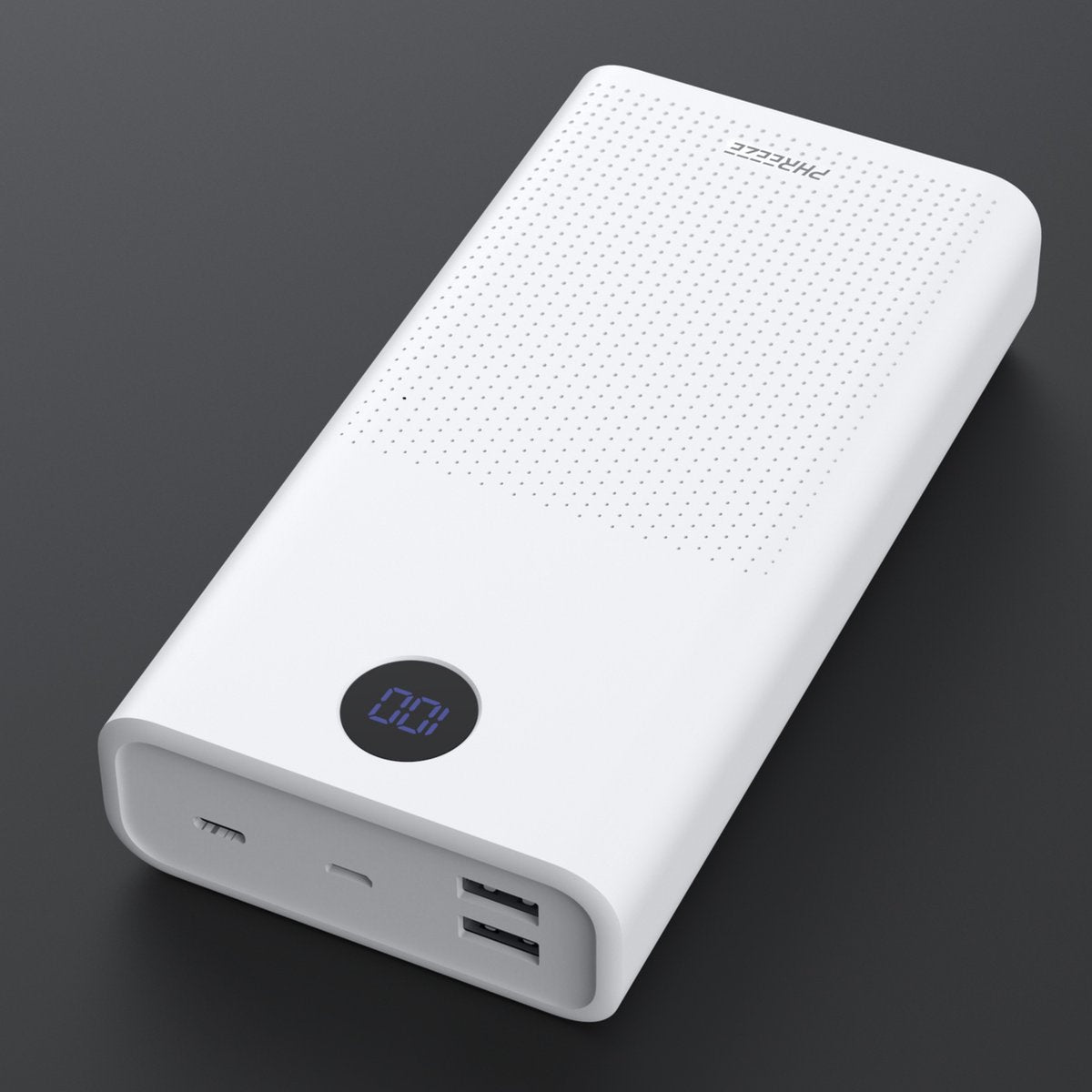 Een witte powerbank met een digitaal display met '100'. Het heeft poorten en een geperforeerde bovenkant. De achtergrond is donkergrijs.