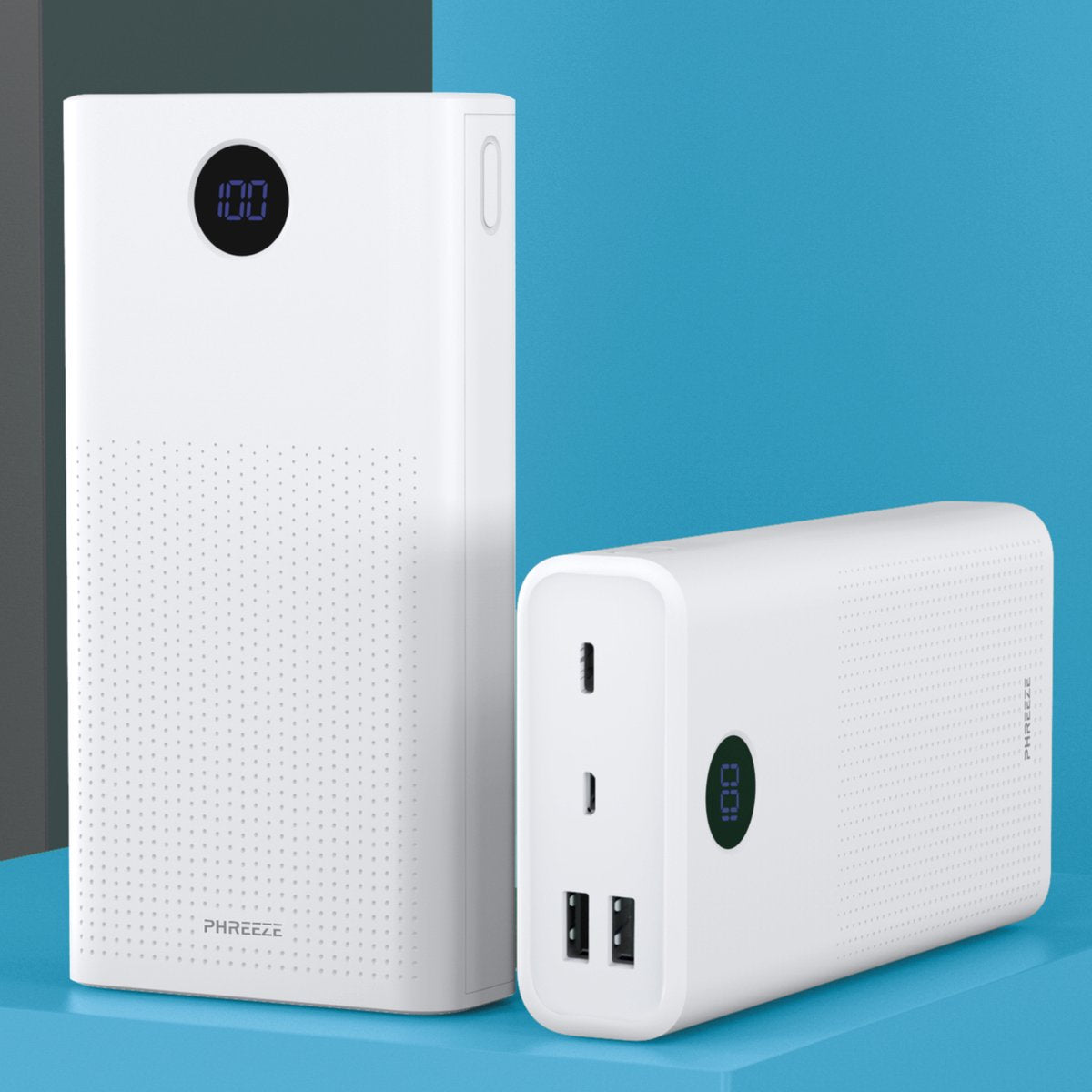 Twee witte powerbanks. Eén is hoog, de andere ligt. Beide hebben digitale displays met 100% lading. De achtergrond is blauw.