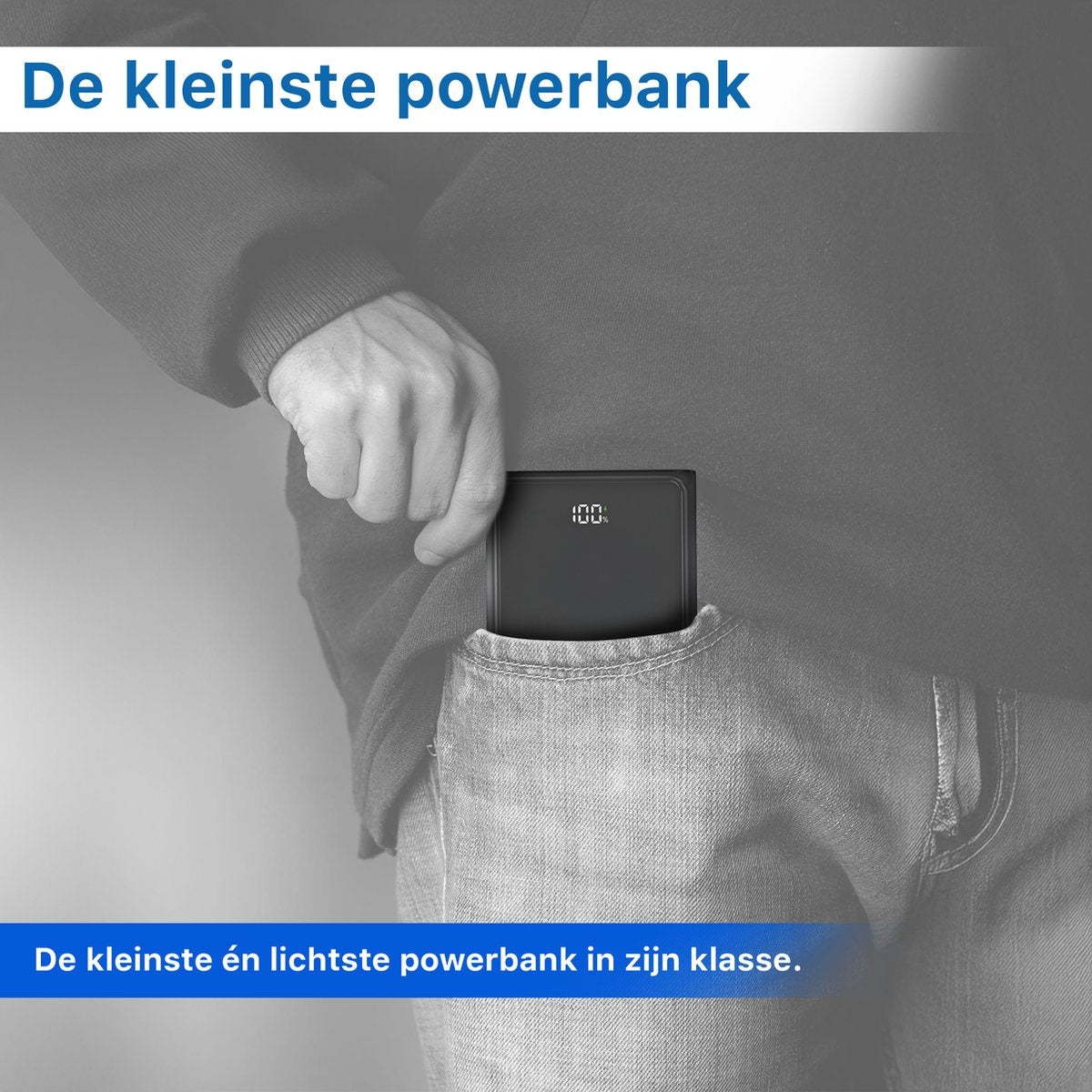 Een hand stopt een zwarte powerbank in een jeanszak. De powerbank geeft 100% aan. Tekst: "De kleinste powerbank".