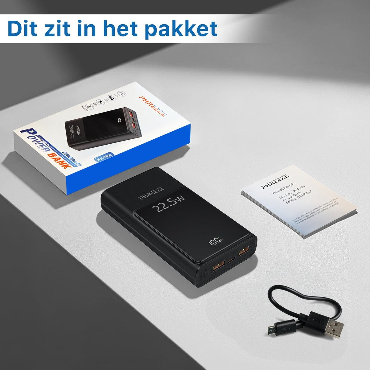 Zwarte powerbank, doos met 20000mAh, instructies en kabel. De tekst 'Dit zit in het pakket' staat erboven.