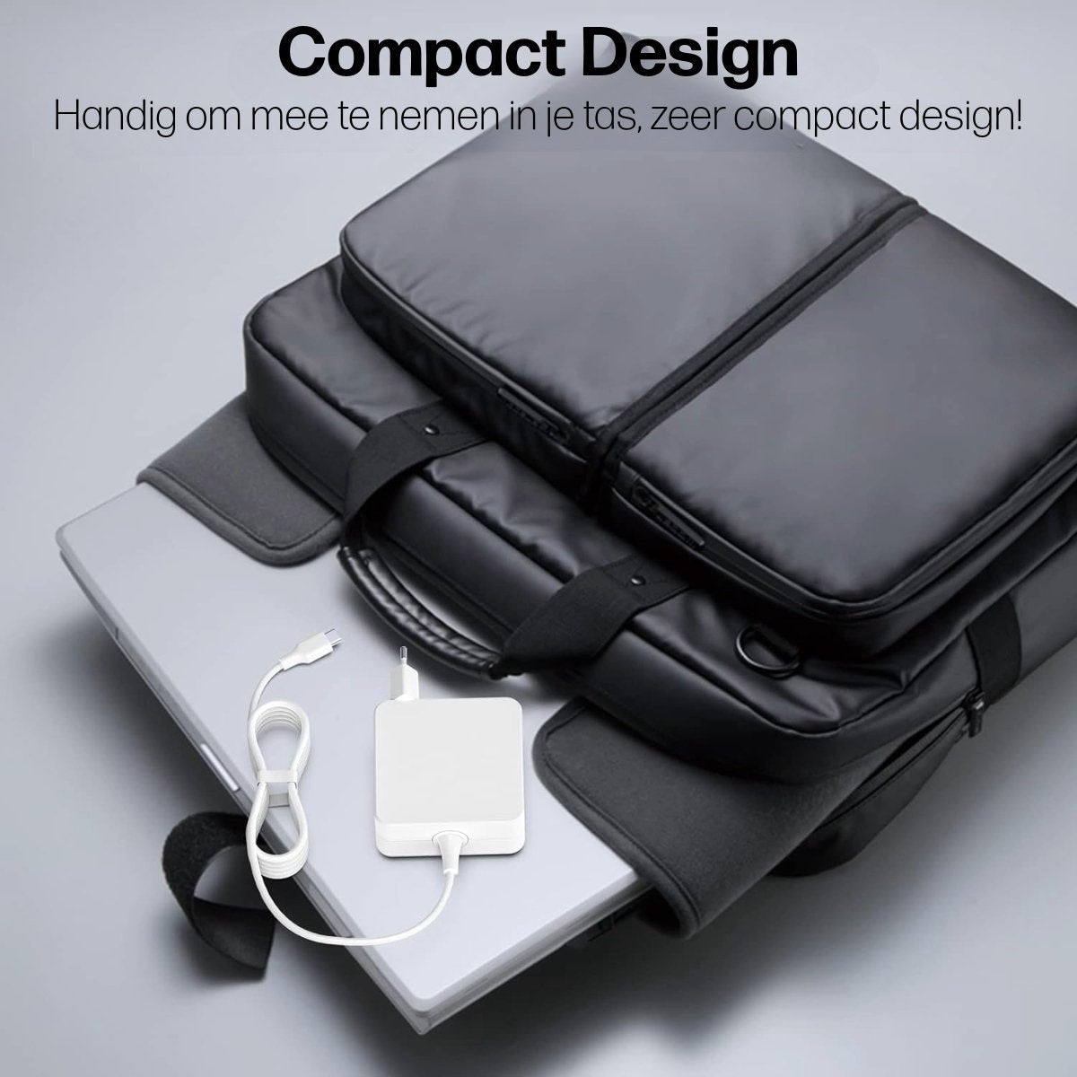 Black laptop bags stacked with a laptop and charger. The bags are on top of each other. White charger and cable are visible.