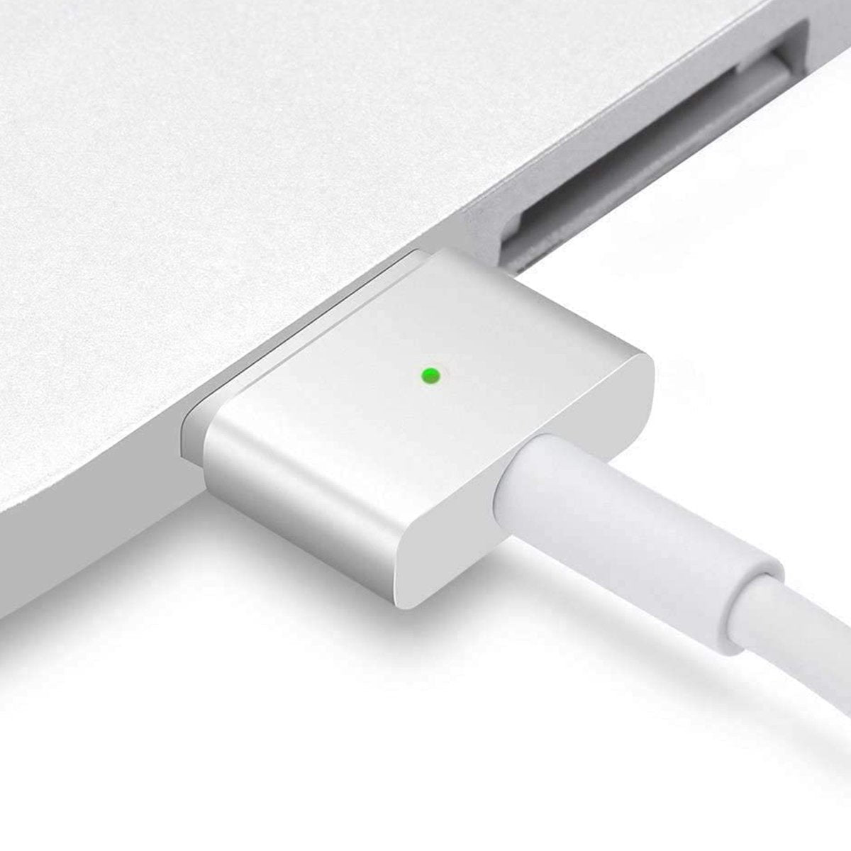 Een witte laptop met een magnetische oplaadpoort. De oplader is aangesloten en een groen lampje geeft het opladen aan.