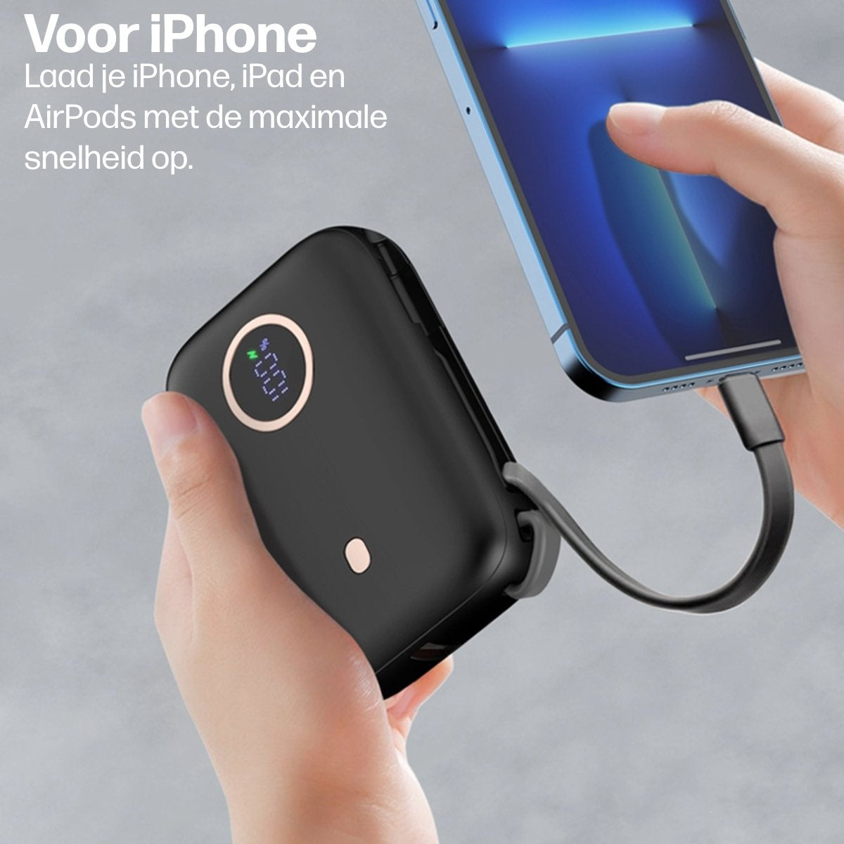 Een zwarte powerbank wordt met één hand vastgehouden, verbonden met een blauwe iPhone. Het telefoonscherm toont een blauwe gradiënt.