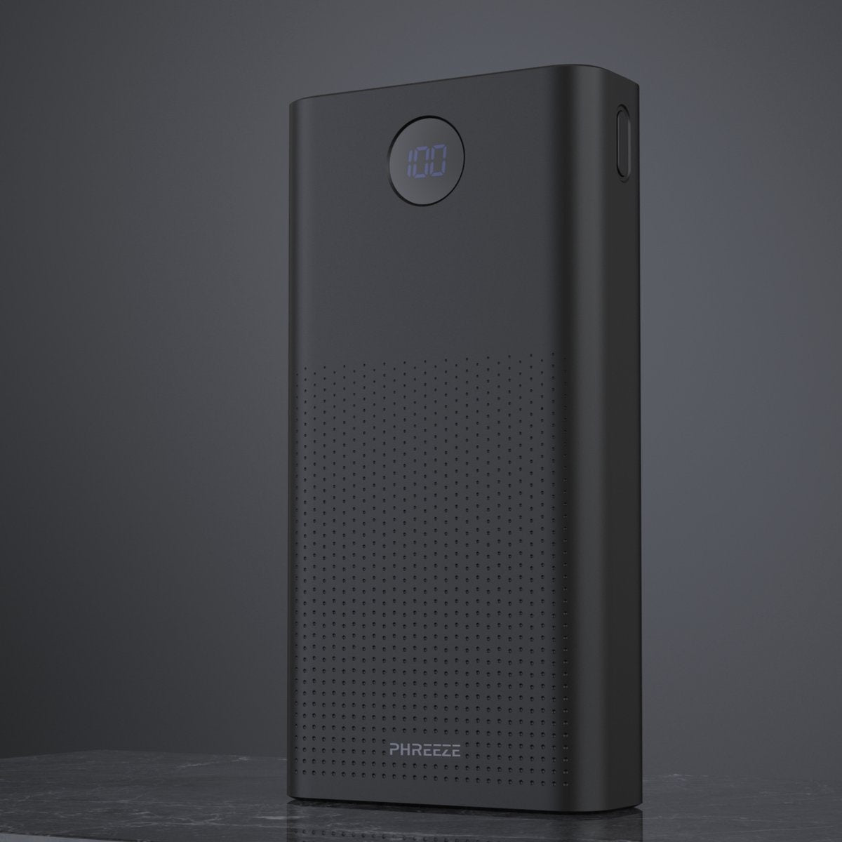 Een zwarte powerbank toont 100%. Het heeft een geperforeerd gedeelte en de merknaam 'PHREEZE'. De achtergrond is een donkergrijze gradiënt.