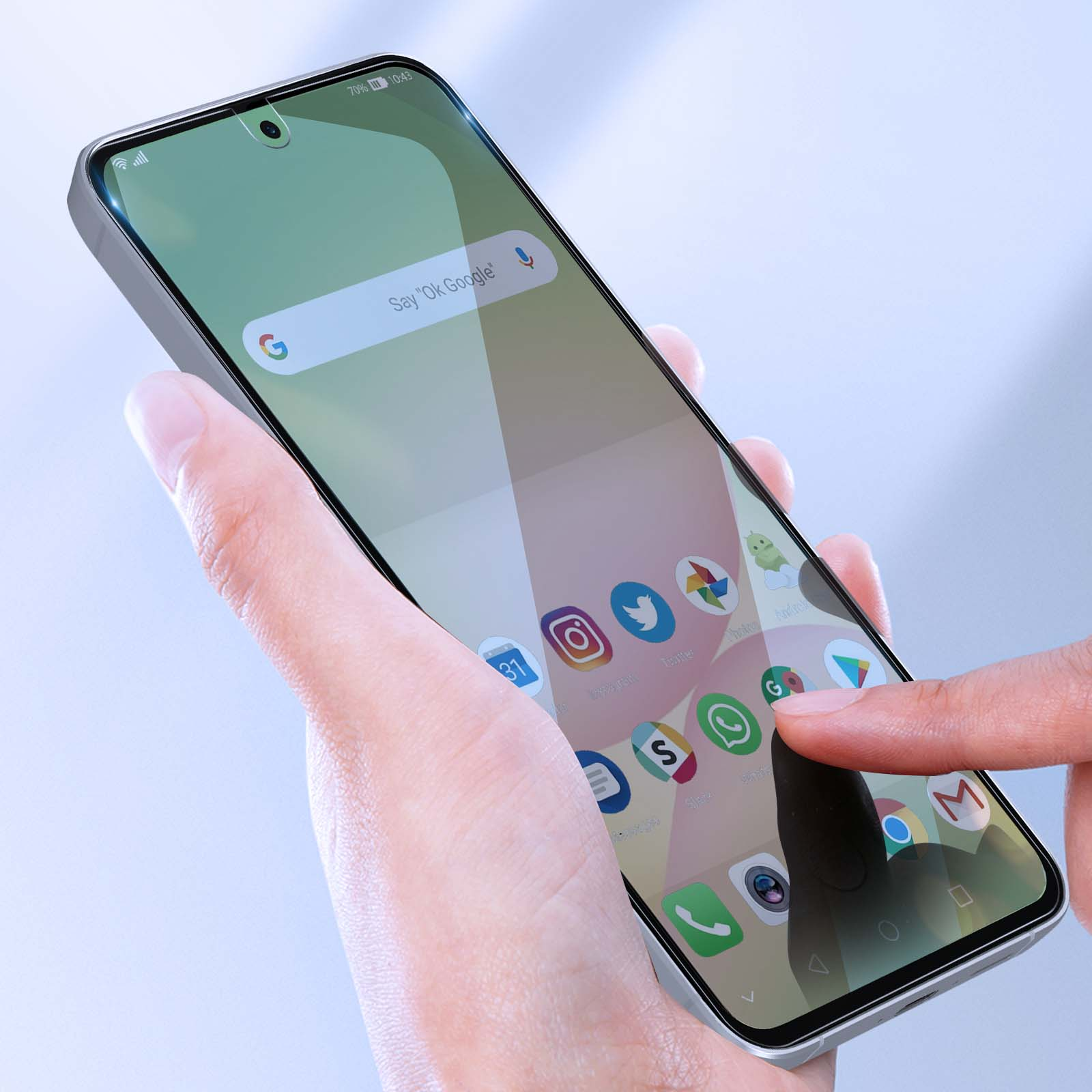 Dłoń trzymająca smartfon. Palec dotyka ikony aplikacji Google na ekranie. Widoczne różne ikony aplikacji. Jasne tło.