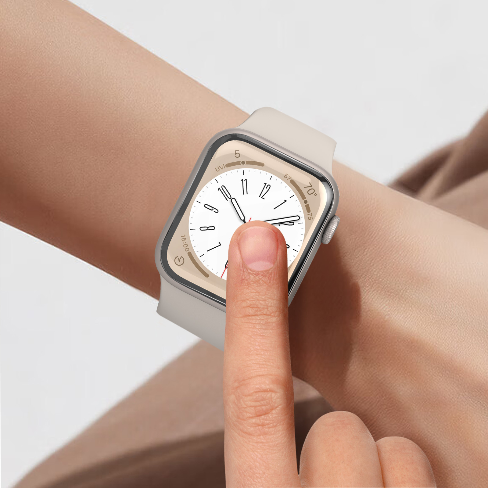 Il polso di una persona con uno smartwatch beige. Un dito tocca il quadrante dell'orologio. L'orologio mostra l'ora.