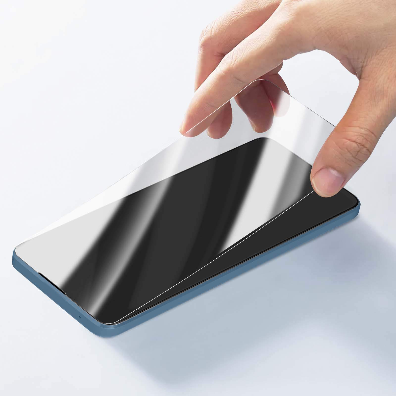 Una mano applica una protezione schermo a uno smartphone blu. La protezione è trasparente e riflette la luce.