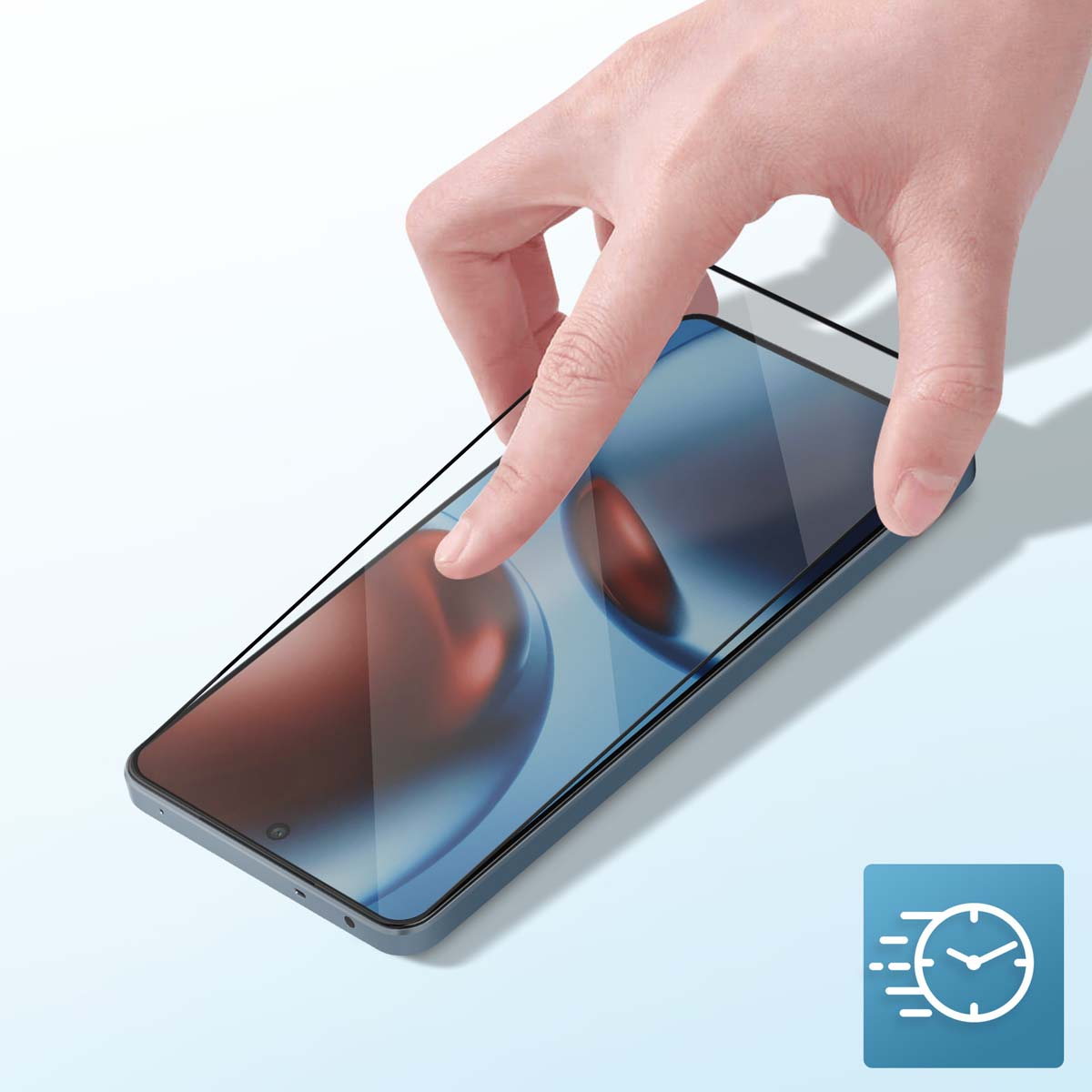 Una mano posiziona una protezione schermo su uno smartphone. Il telefono è blu scuro, lo schermo ha un'immagine sfocata e lo sfondo è azzurro.
