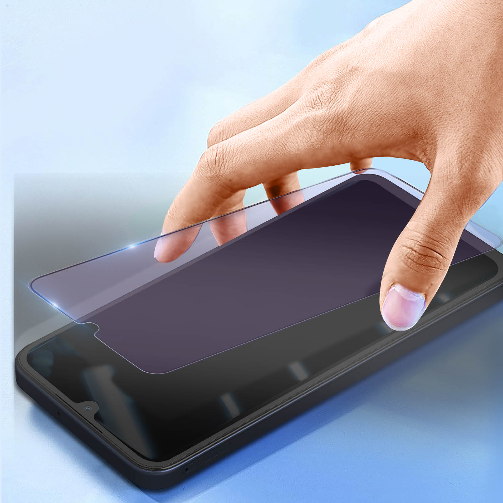 Una mano applica una protezione schermo su uno smartphone nero. La protezione è un foglio colorato. Lo sfondo è azzurro.