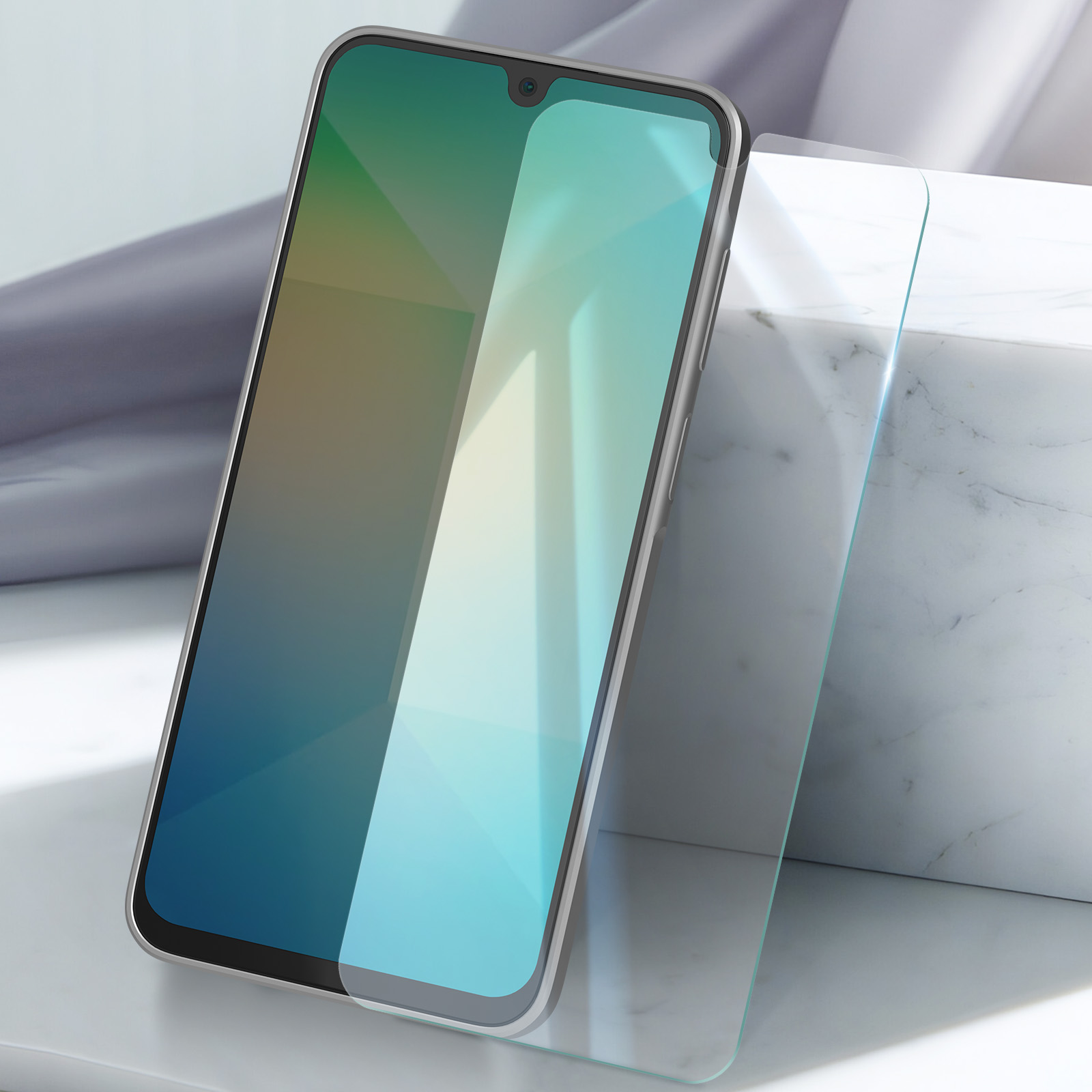 Uno smartphone con una protezione schermo è su una superficie bianca, vicino a un blocco di marmo bianco. Lo schermo è acceso.