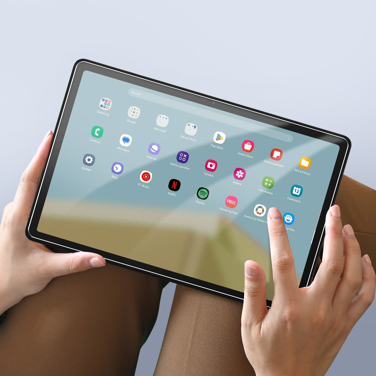 Una persona tiene in mano un tablet con icone di app, toccando lo schermo con un dito.