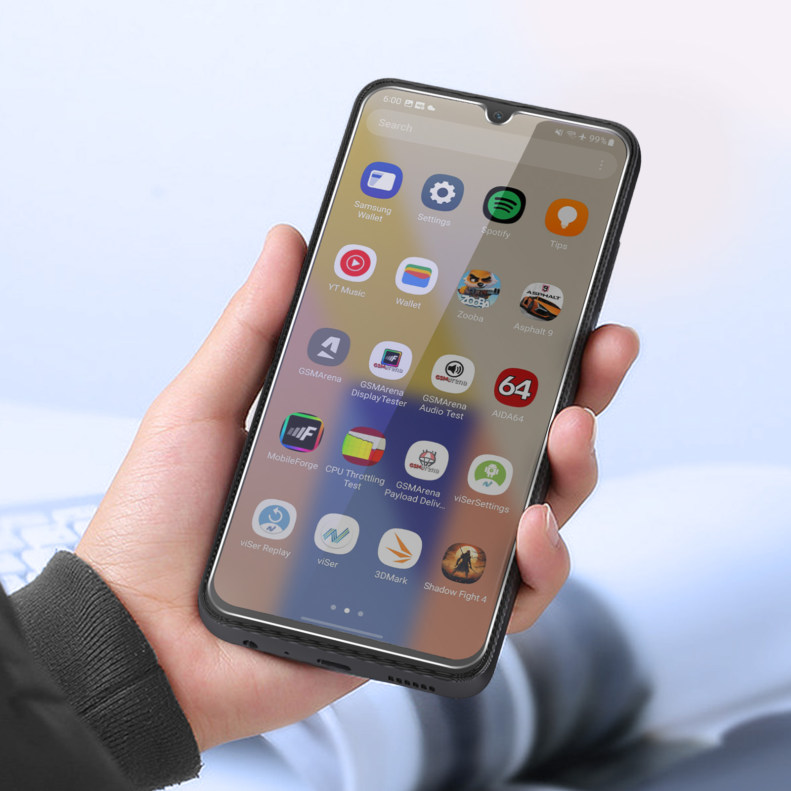 Una mano che tiene in mano uno smartphone che mostra icone di app. Lo schermo mostra app come Spotify e Asphalt 9.