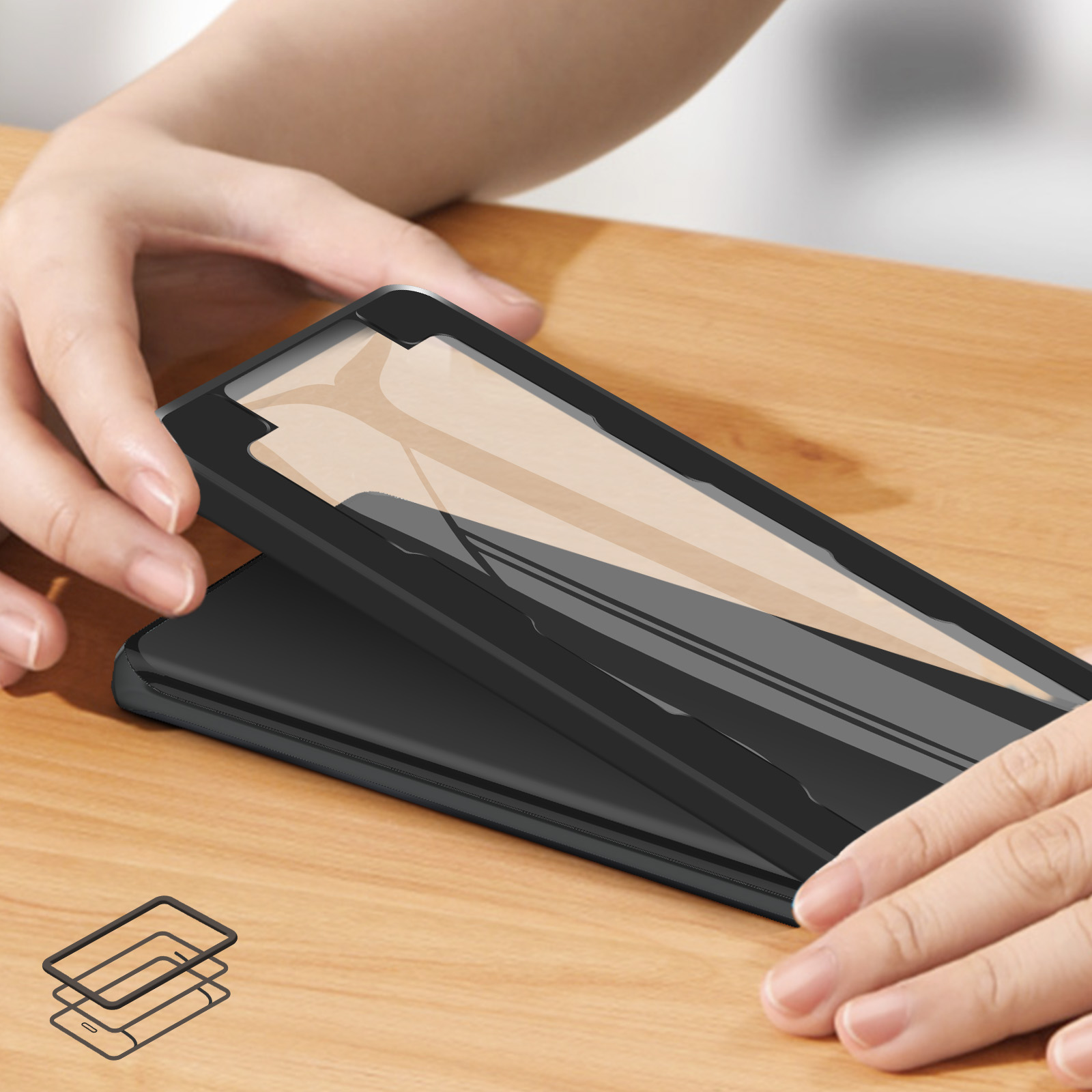Le mani tengono una custodia nera per telefono sopra un telefono, su una superficie di legno. La custodia ha una protezione schermo trasparente.