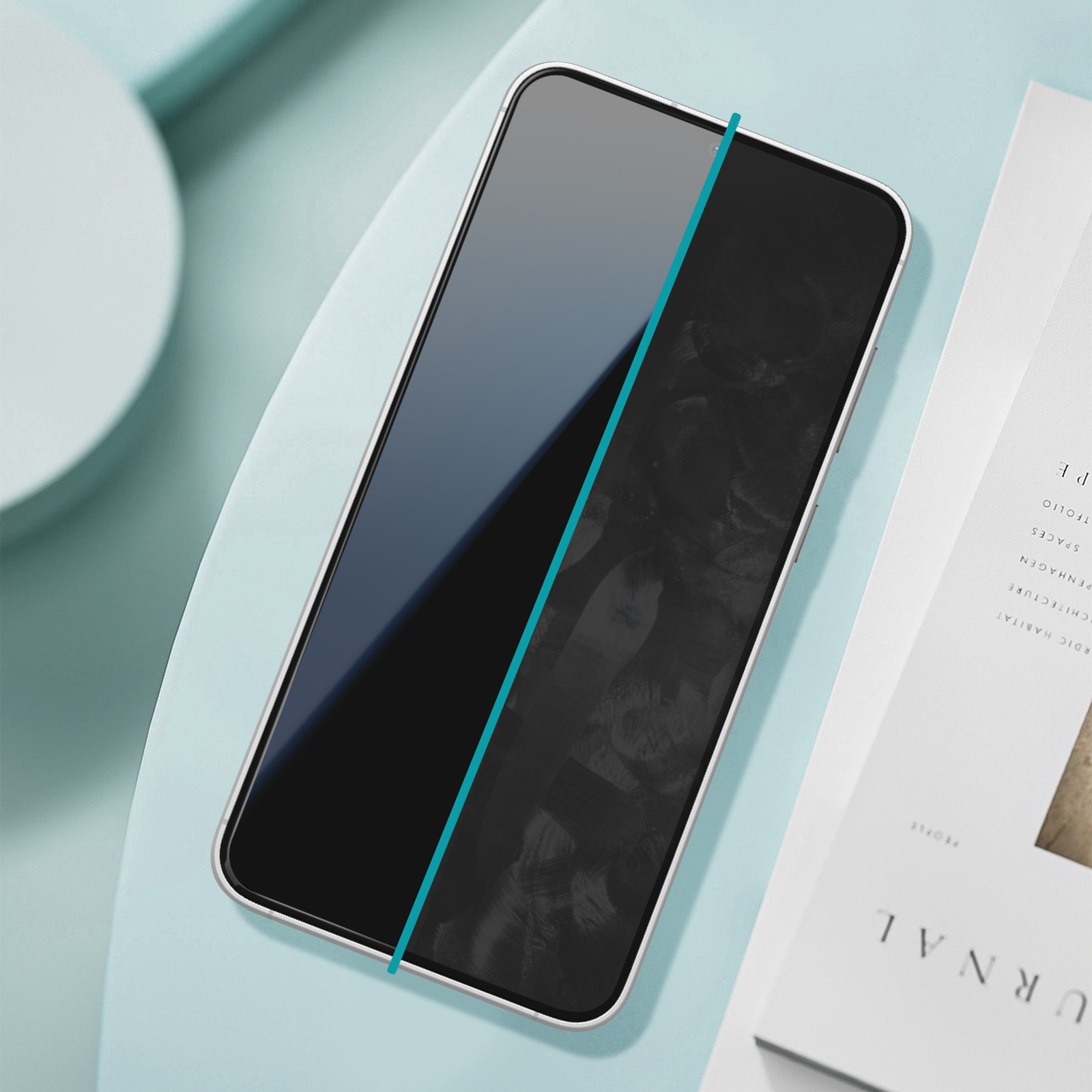 Uno smartphone con schermo nero, una linea verde acqua e un libro bianco su una superficie verde acqua.