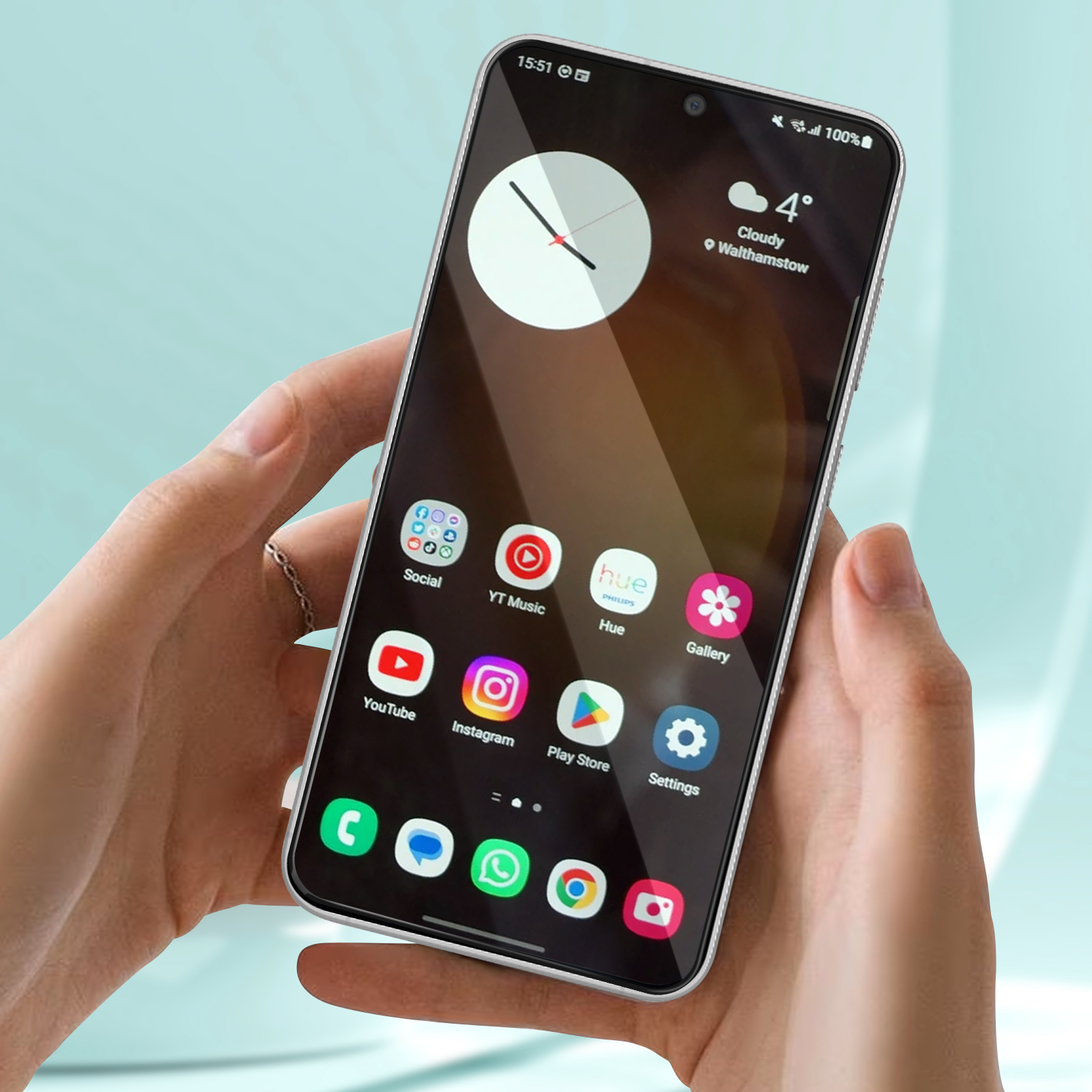 Uno smartphone mostra le icone delle app. Lo schermo mostra un orologio, i dettagli meteo e app come YouTube e Instagram. È tenuto da due mani.