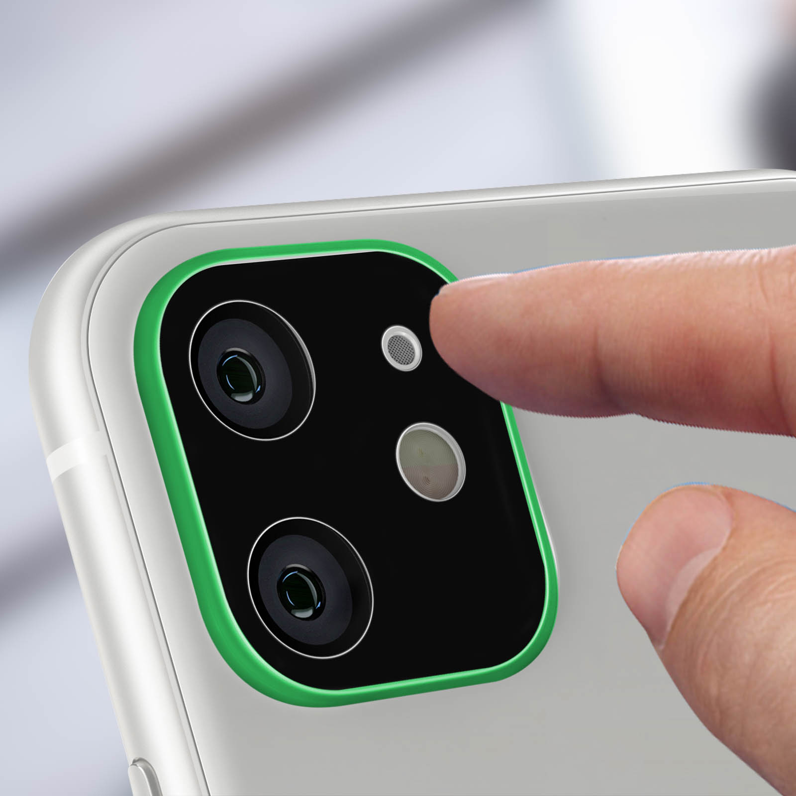 Una mano tocca la fotocamera di un telefono. Il telefono è bianco con un anello verde. Le fotocamere sono nere.
