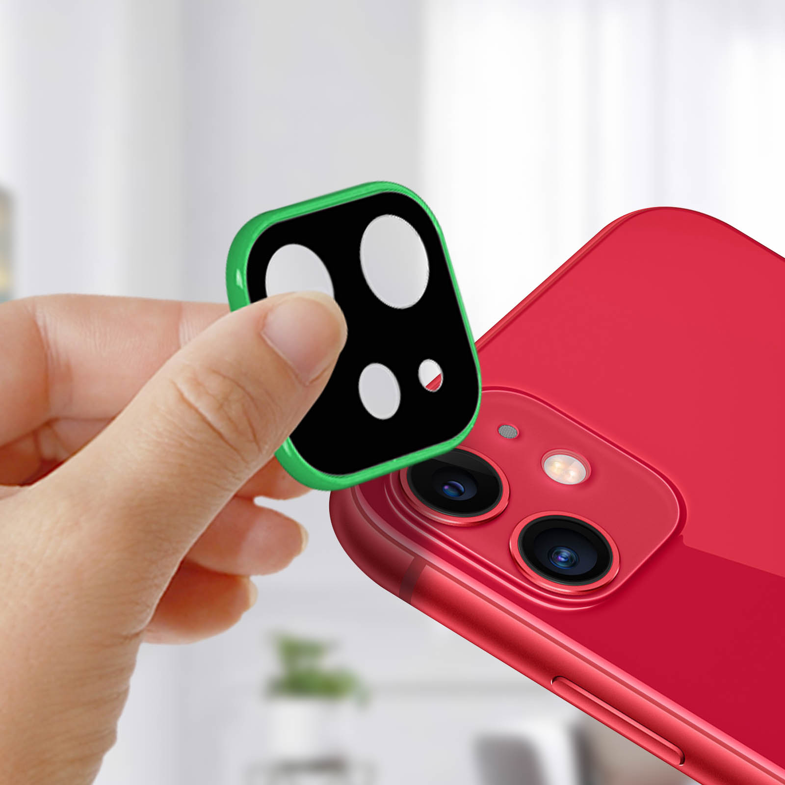 Una mano che tiene una protezione per obiettivo della fotocamera con bordo verde sopra un iPhone rosso con tre obiettivi.