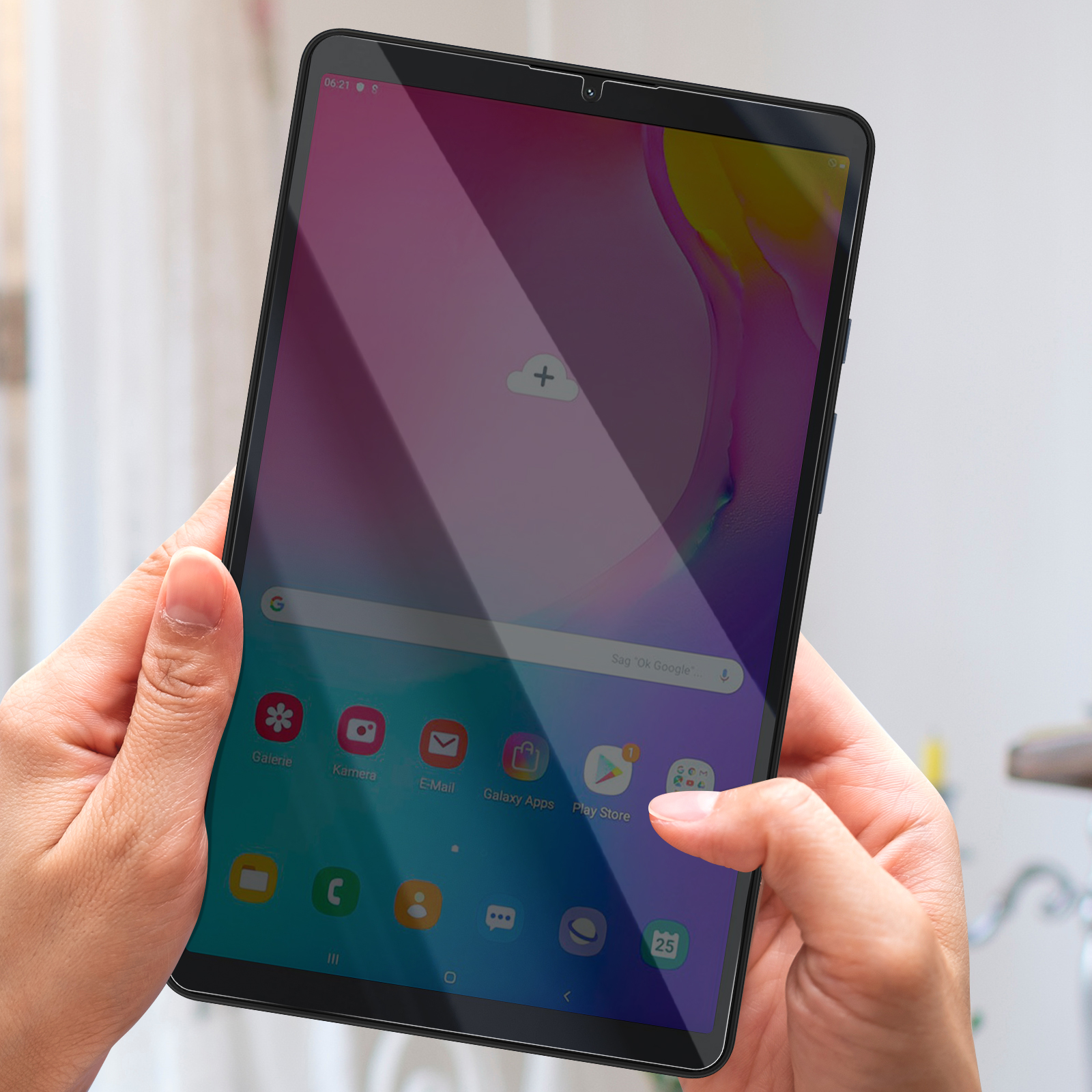 Una persona tiene in mano un tablet con touchscreen che mostra delle app. Il dito della persona tocca lo schermo. Lo sfondo è sfocato.