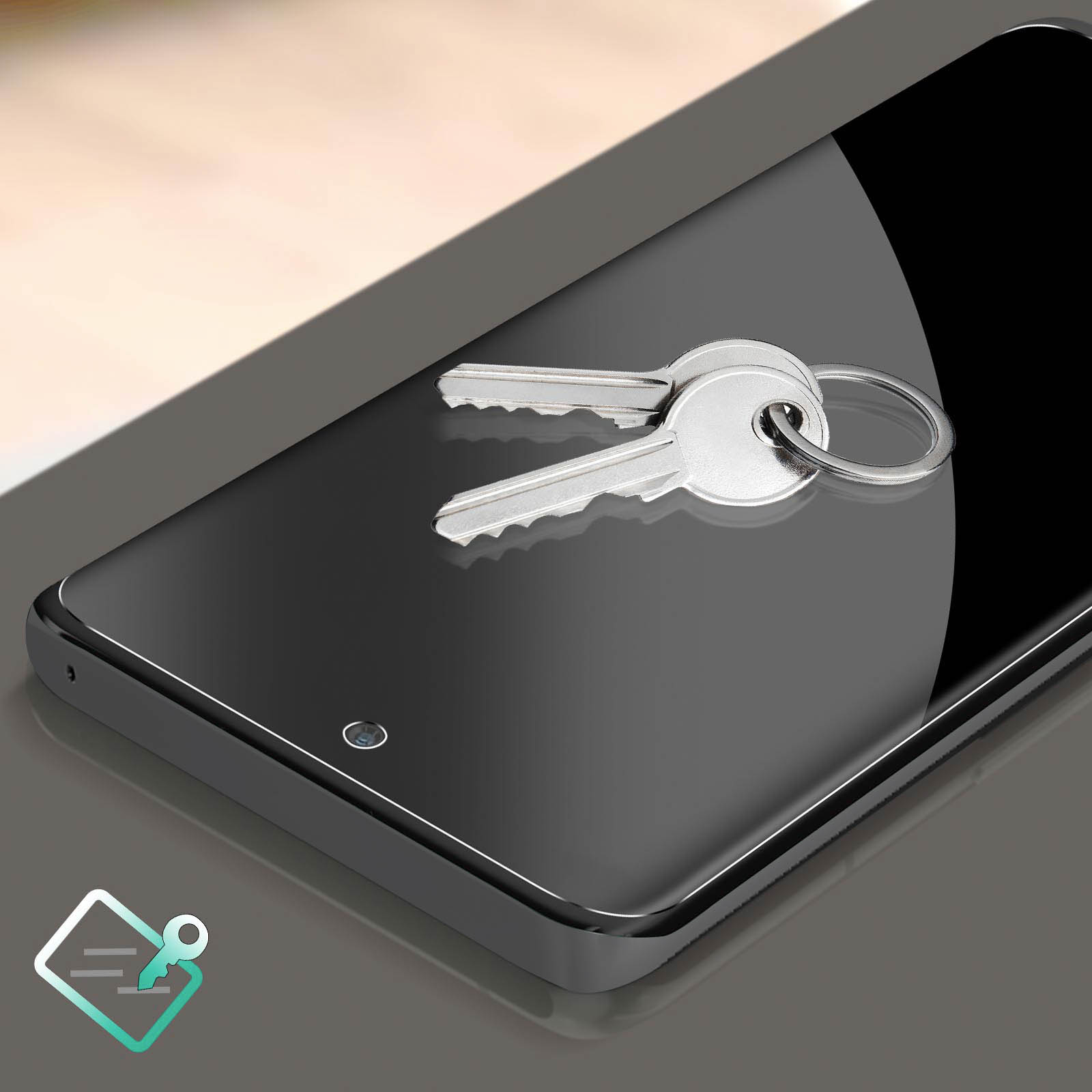 Uno smartphone con delle chiavi sopra. Il telefono è nero, le chiavi sono argentate. Lo sfondo è grigio.