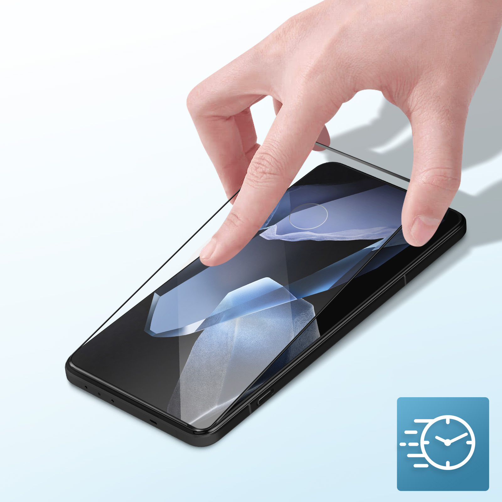 Una mano posiziona una protezione per lo schermo su uno smartphone nero. Il telefono è su una superficie azzurra. Un'icona di velocità è nell'angolo.