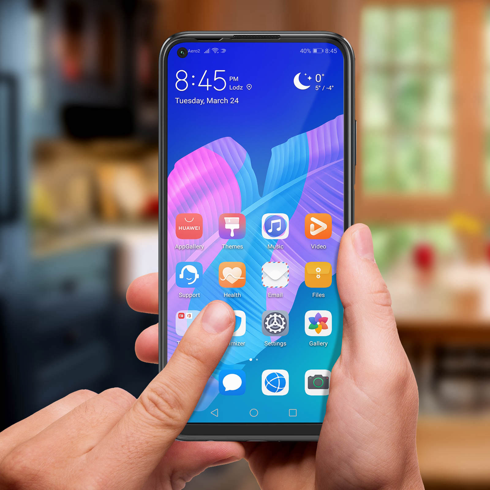 Una mano tiene in mano uno smartphone che mostra icone di app. Lo schermo mostra l'ora, la data e il meteo. Il dito tocca lo schermo.