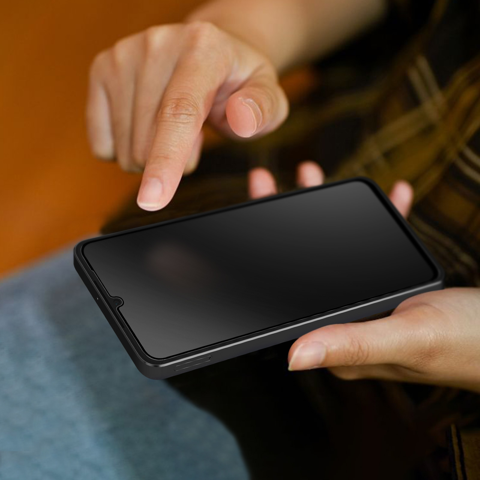 Mani che tengono uno smartphone nero, un dito punta lo schermo. Lo sfondo è sfocato.
