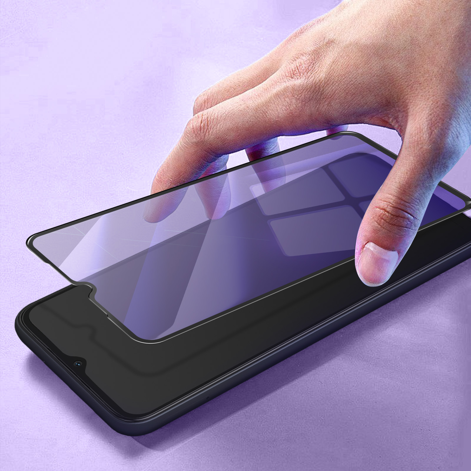 Una mano che applica una protezione per lo schermo su uno smartphone nero. Sfondo viola.
