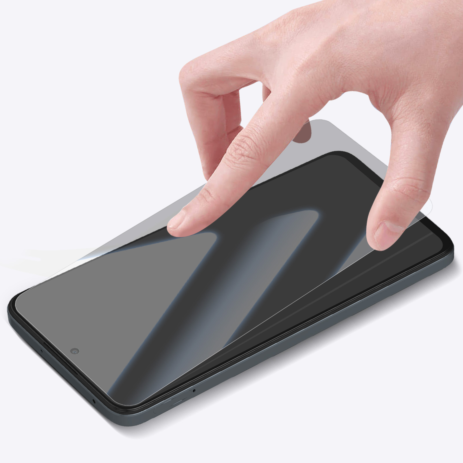 Una mano applica una protezione per lo schermo a uno smartphone. Il telefono è grigio scuro. Lo sfondo è bianco.