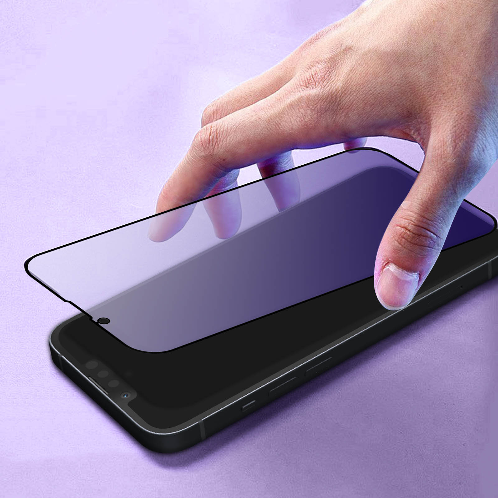 Una mano sta applicando una protezione schermo su uno smartphone nero. La protezione è viola, lo sfondo è lavanda.