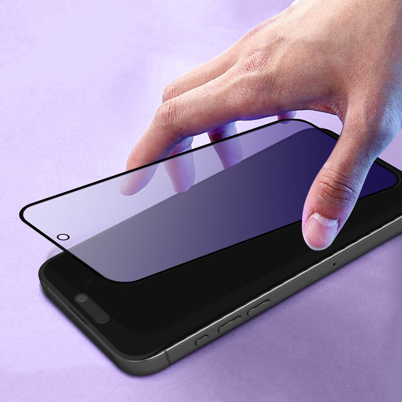Una mano posiziona una protezione per lo schermo su uno smartphone nero. La protezione è trasparente con una sfumatura viola. Sfondo viola.