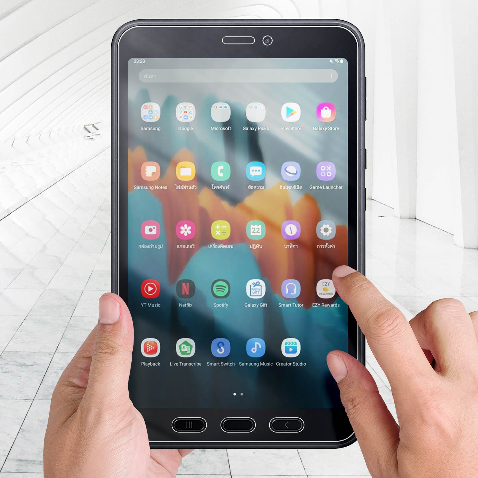 Una mano tocca lo schermo di un tablet che mostra icone di app. Lo sfondo mostra un corridoio bianco.