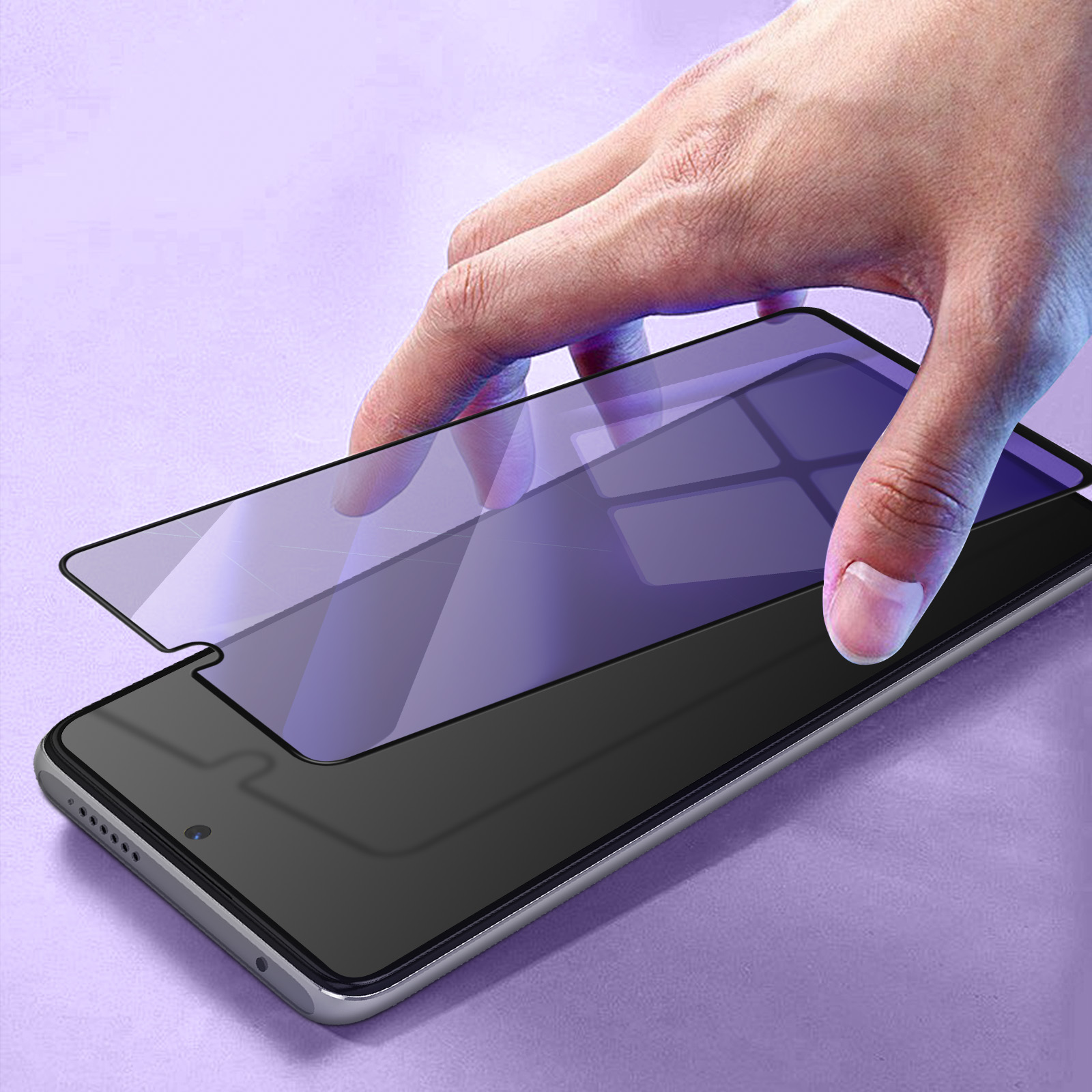 Mano che applica una protezione per lo schermo su un telefono. La protezione è viola, il telefono nero.