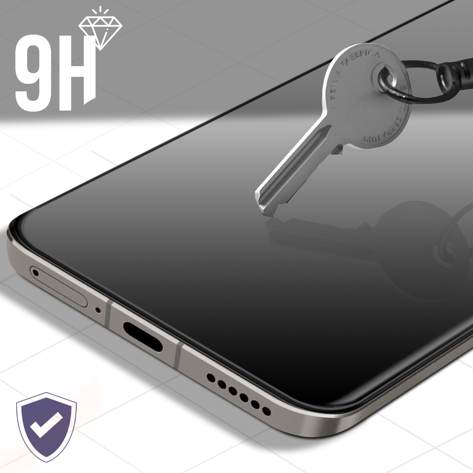 Un proteggi schermo per smartphone con una chiave sopra. Il telefono è nero, la chiave è argentata. Lo sfondo è una griglia.