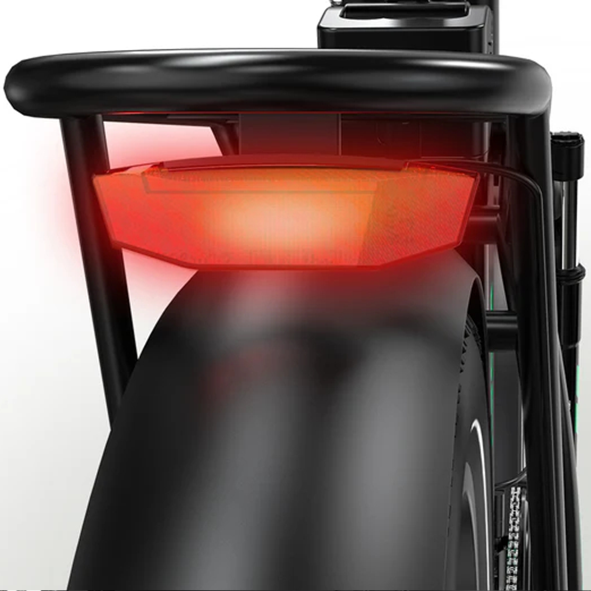 Zbliżenie tyłu roweru. Czerwone światło tylne jest włączone, nad czarną oponą i błotnikiem. Widoczne są czarne detale bagażnika i ramy.