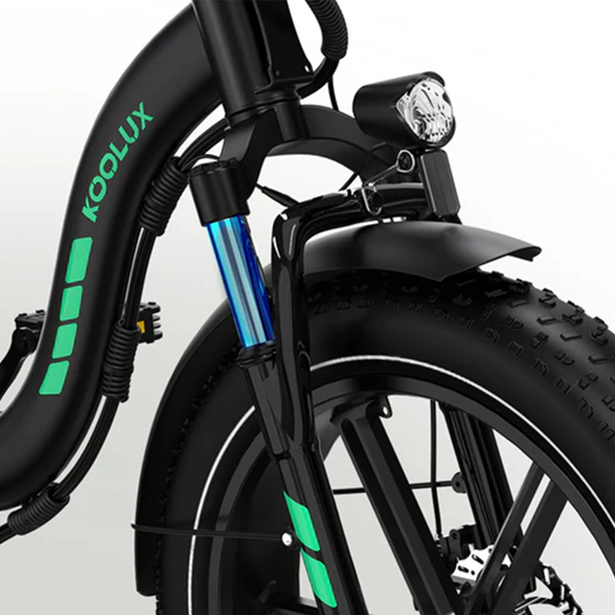 Zbliżenie czarnego roweru elektrycznego Koolux. Posiada przednie koło, reflektor i niebieskie zawieszenie. Zielone akcenty na ramie.