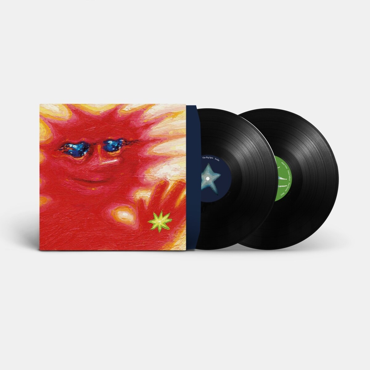 Copertina dell'album con un volto rosso simile al sole e due dischi in vinile neri. La copertina ha occhi blu e una stella verde.