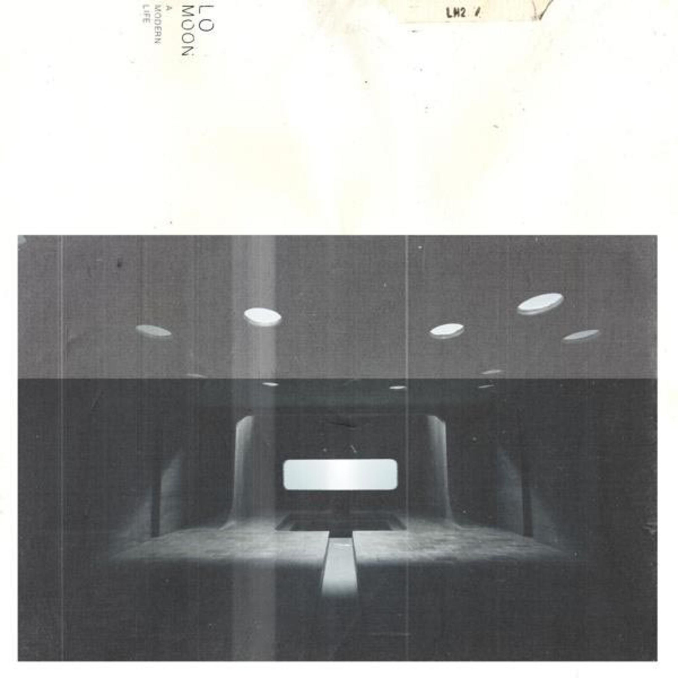 Immagine architettonica in scala di grigi. Le luci ovali a soffitto illuminano uno spazio interno. Un'apertura rettangolare è alla fine della stanza.