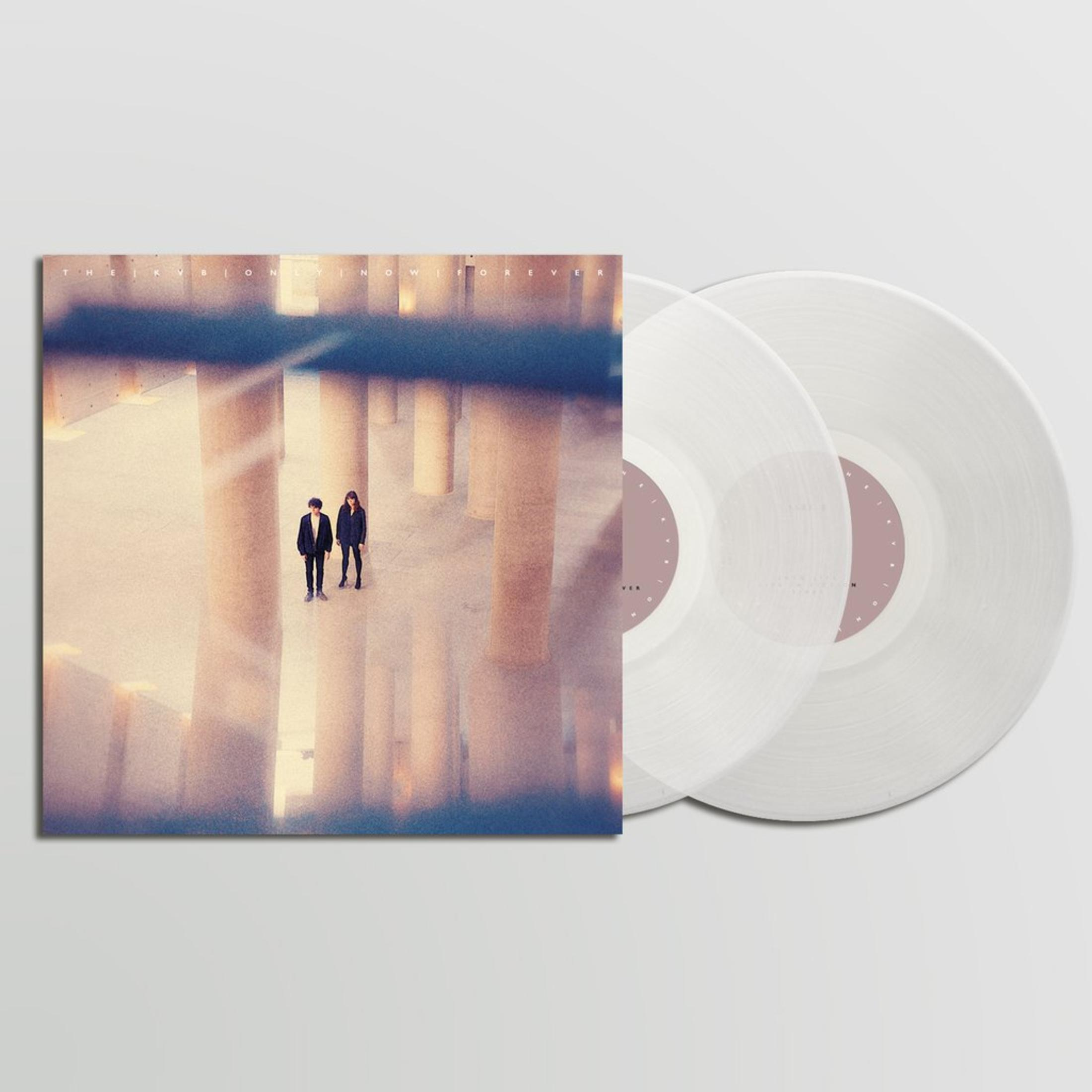 Albumcover mit zwei Personen, die in einem Flur stehen. Zwei Schallplatten befinden sich neben dem Cover.