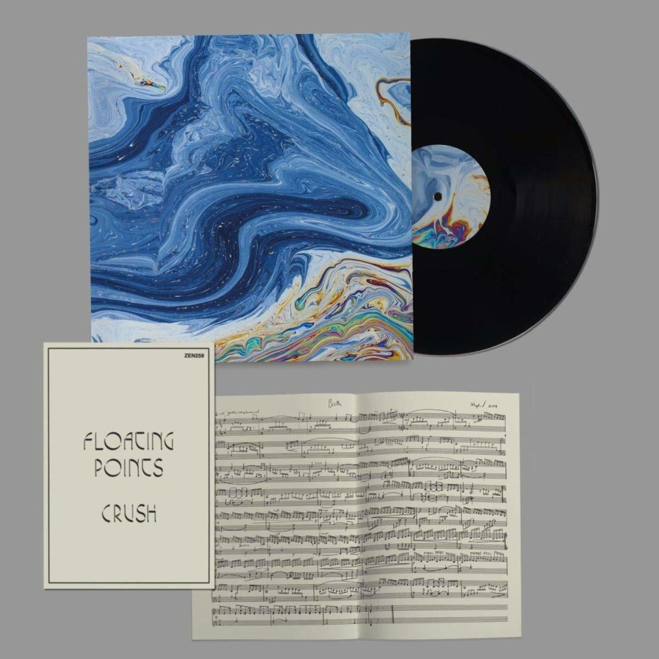 Un disco in vinile, copertina dell'album con design a spirale blu e bianco, spartiti e grafica dell'album per Floating Points, Crush.