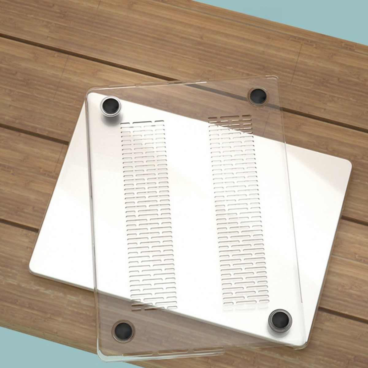 Transparente Laptop-Hülle auf Holzoberfläche. Die Hülle hat Luftschlitze und schwarze Gummifüße. Der Hintergrund ist ein Holztisch.