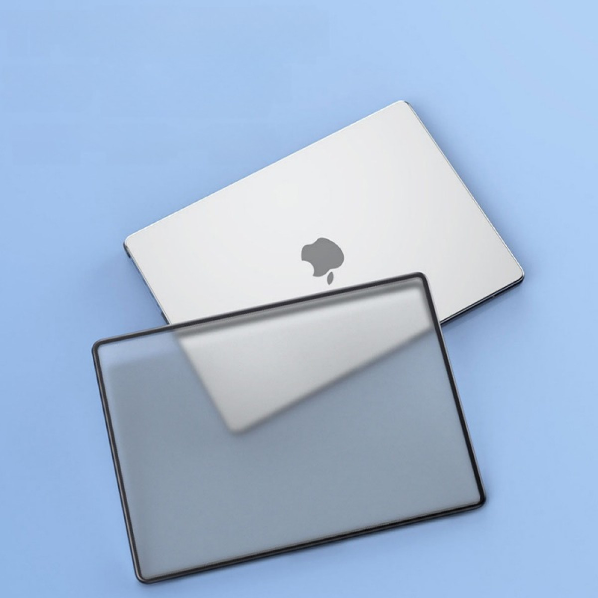 Ein silberner Laptop mit Apple-Logo liegt auf einer blauen Oberfläche. Eine transparente Hülle liegt davor.