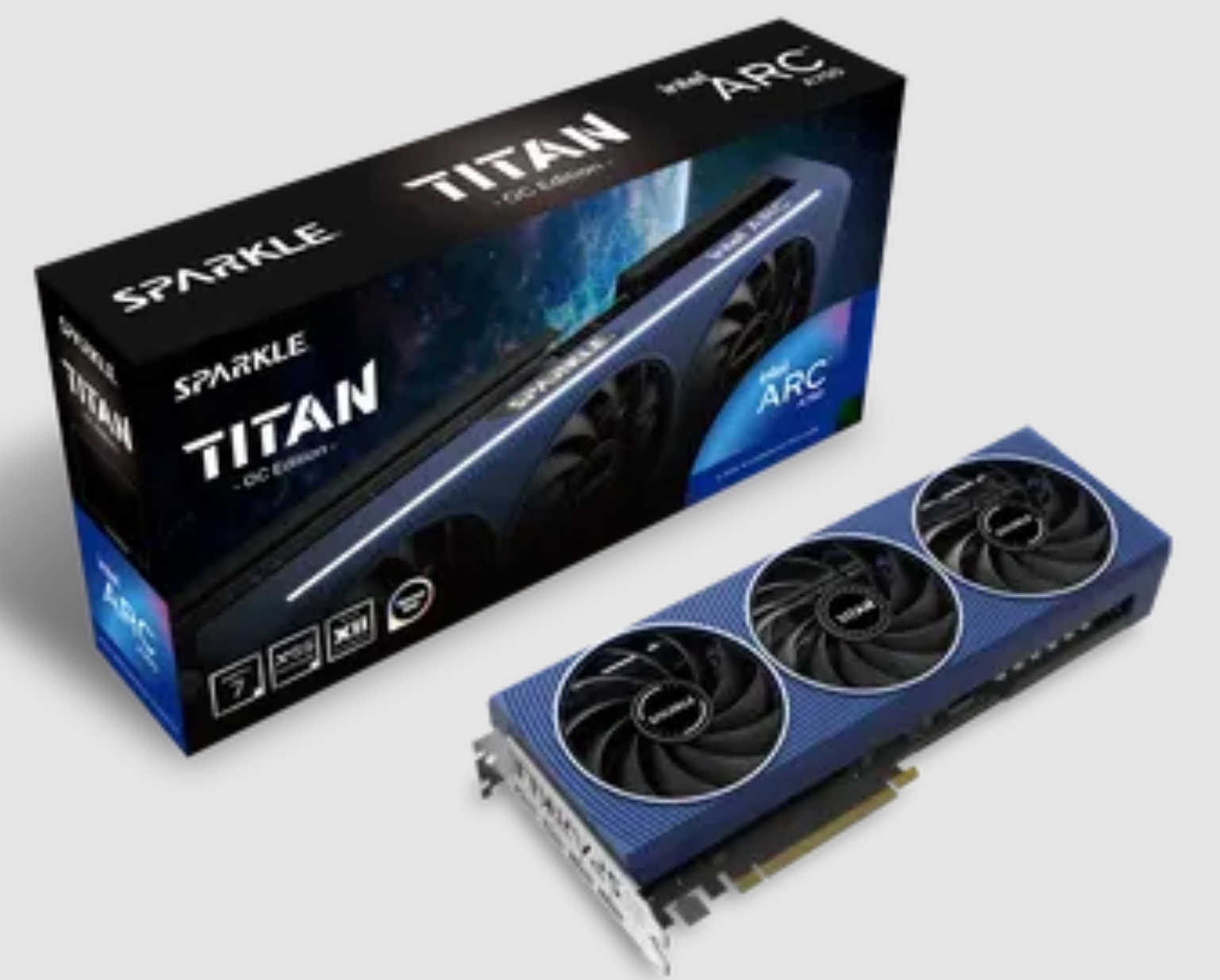 Karta graficzna Sparkle Titan ARC A770 i jej pudełko. Karta jest niebieska z trzema wentylatorami. Pudełko jest czarne i niebieskie.