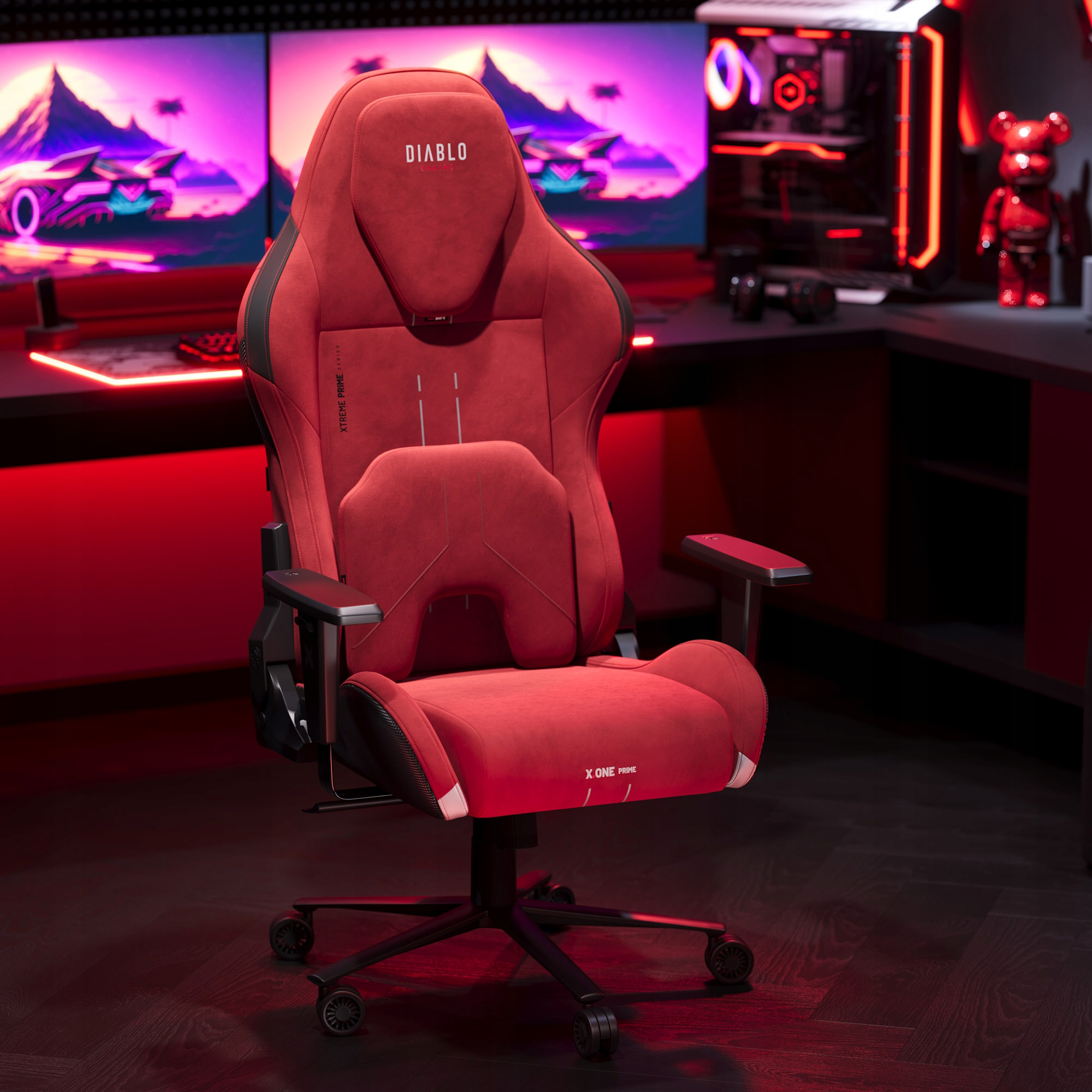Czerwony fotel gamingowy z zagłówkiem 'DIABLO' i oparciem. Znajduje się w konfiguracji gamingowej z monitorami i PC.